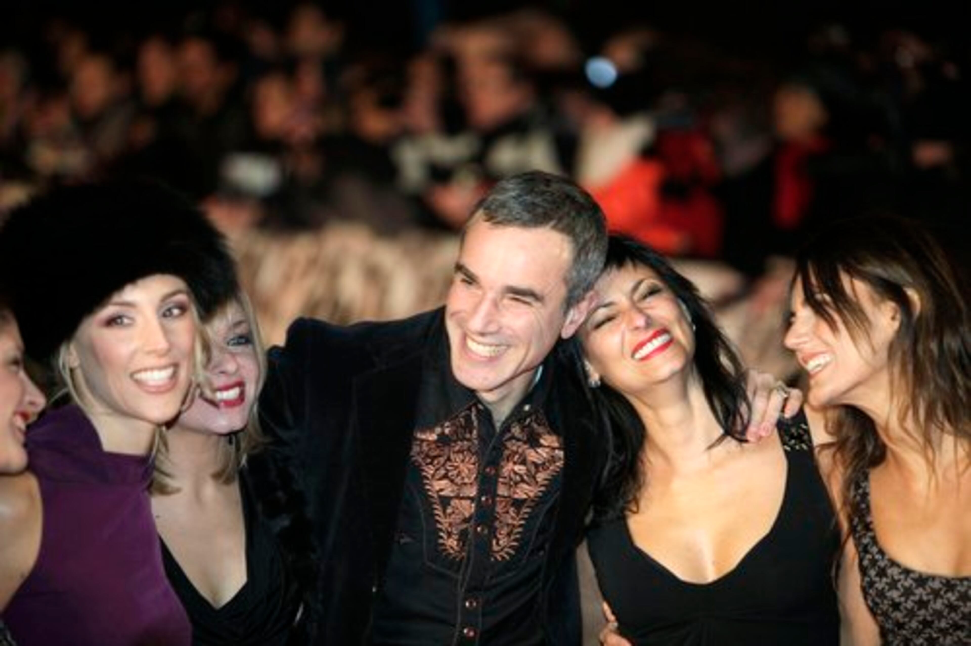 Actor Daniel Day-Lewis, center, jokes as he poses for the photographers with dancers starring on his latest film 'Nine' prior to the world premiere in central London.