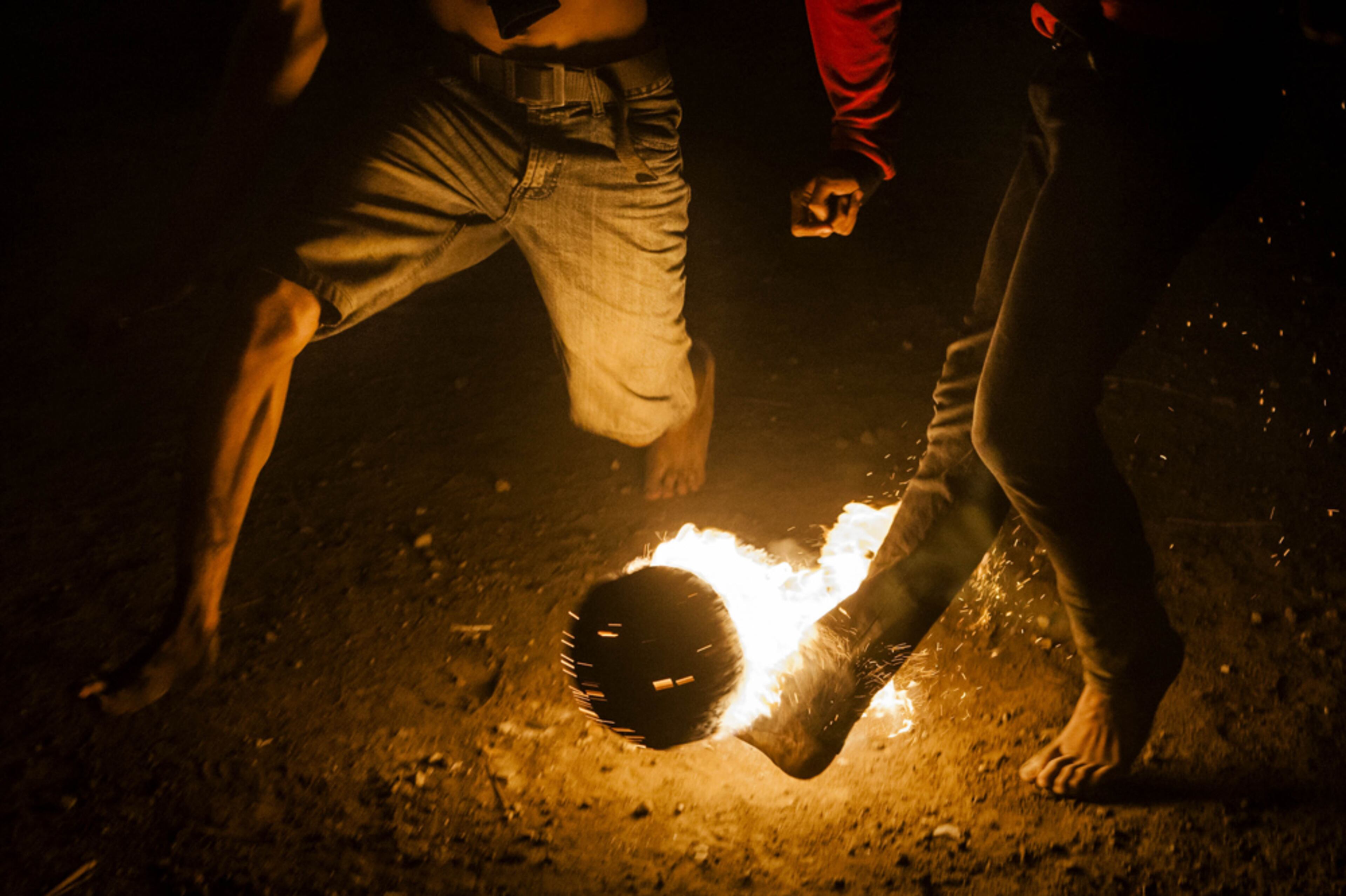 FIRE BALL--YOGYAKARTA, INDONESIA - AUGUST 16: A coconut is soaked in kerosene and set on fire for 'fire football' during celebrations of Indonesia's National Independence Day on August 16, 2014 in Yogyakarta, Indonesia. Indonesia became an independent nation on August 17, 1945 having previously been under Dutch rule. (Photo by Ulet Ifansasti/Getty Images)