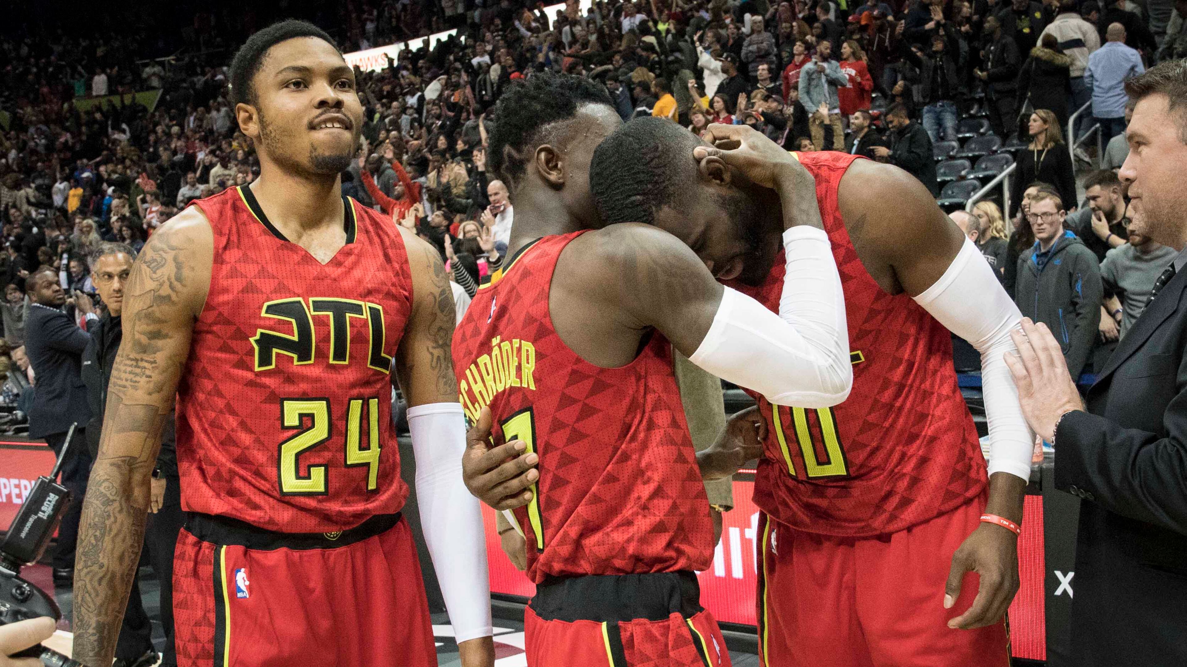 Atlanta Hawks guards Tim Hardaway Jr. (10) and Dennis Schroder congratulate each other as forward Kent Bazemore (24) watches after the team’s NBA basketball game against the San Antonio Spurs, Sunday, Jan. 1, 2017, in Atlanta. Atlanta won 114-112 in overtime. (AP Photo/John Amis)