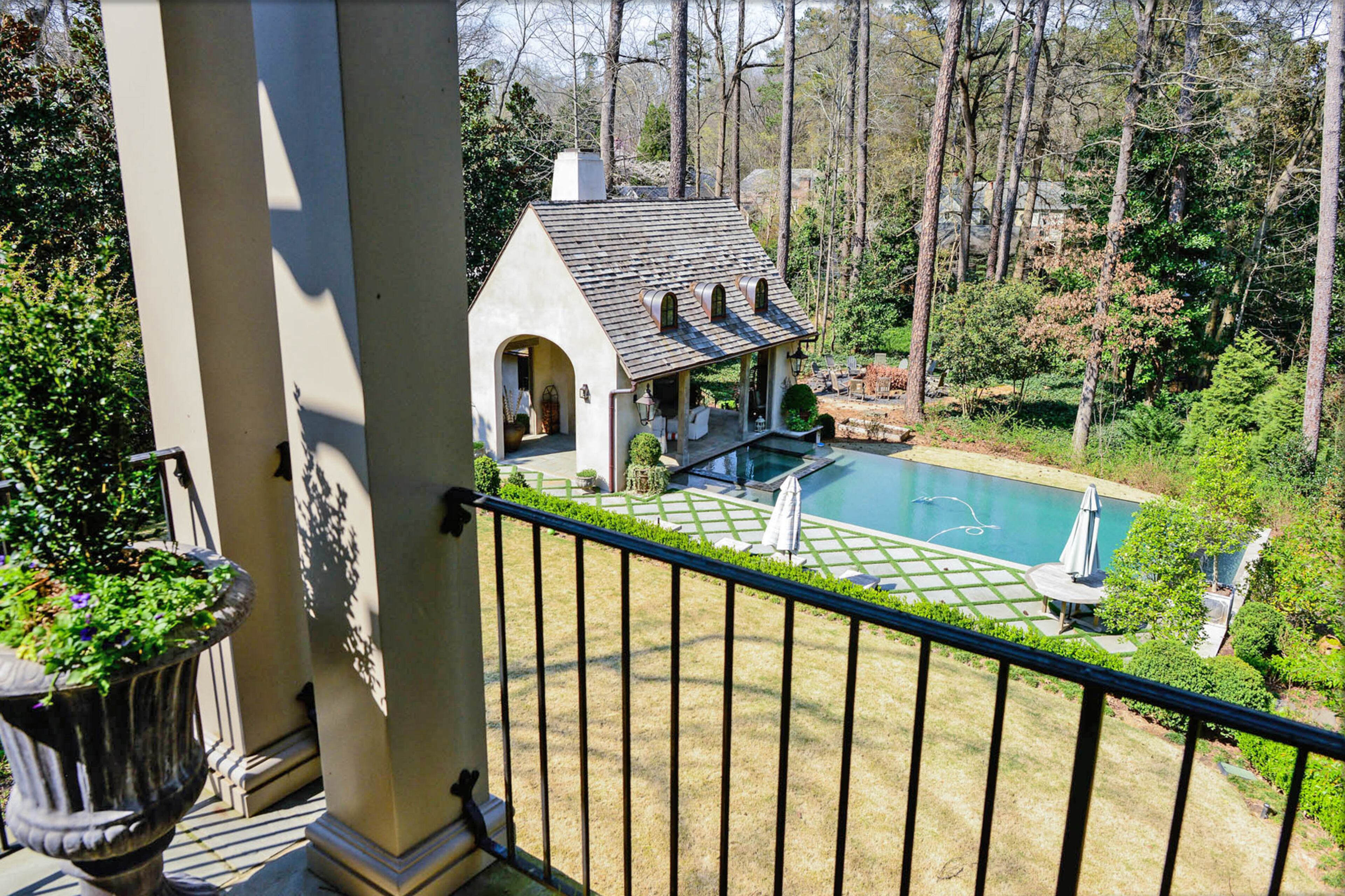 A balcony looks onto Dina Woodruff's pool and pool cabana with a fireplace and television. She enjoys being able to light a fire, swim or just sit by the pool.