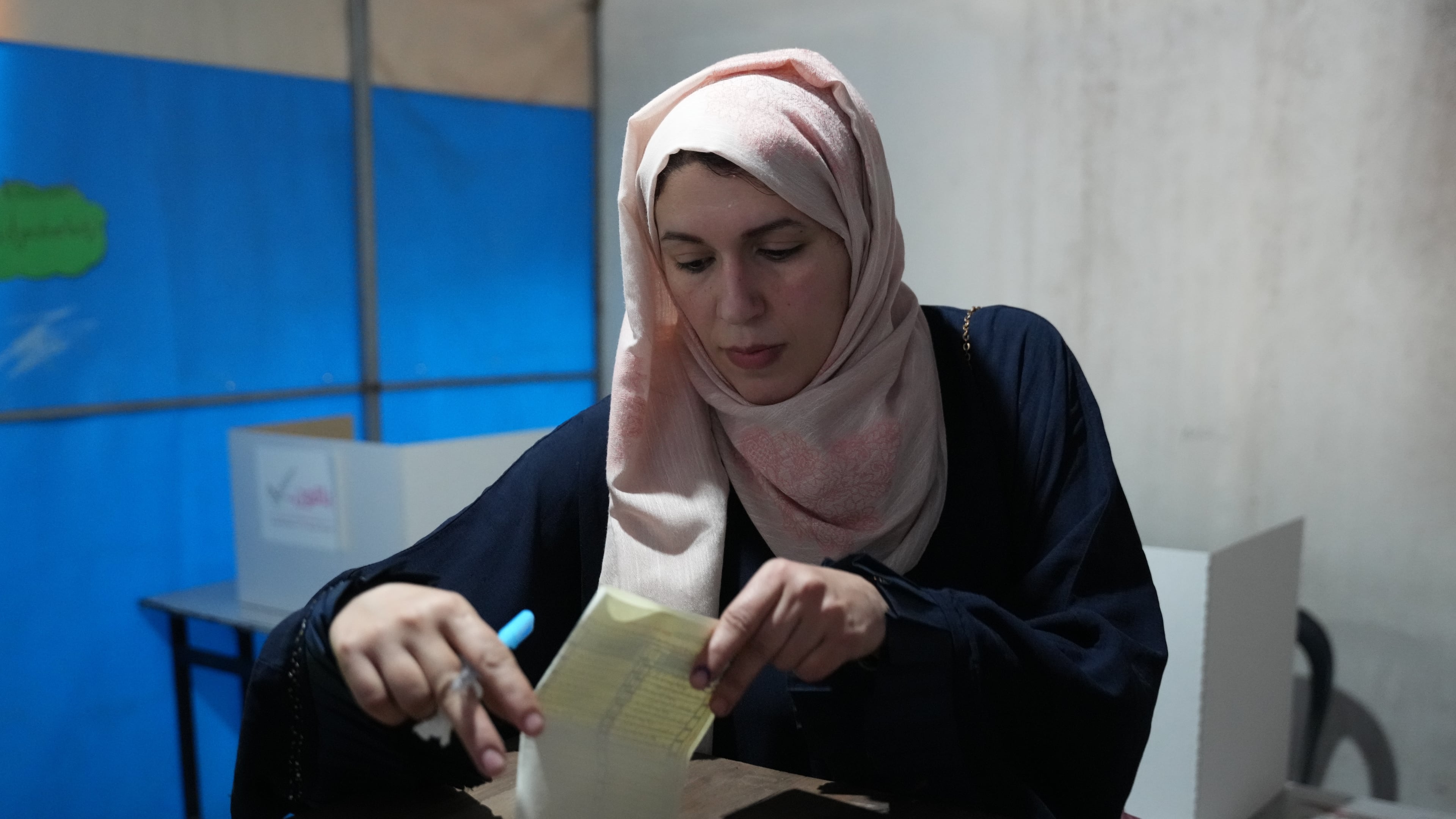A Palestinian woman places her ballot vote for local elections, the first in two decades in Gaza and the first in the occupied West Bank since the start of the Israel-Hamas war in Deir al-Balah, central Gaza Strip, Saturday, April 25, 2026. (AP Photo/Abdel Kareem Hana)