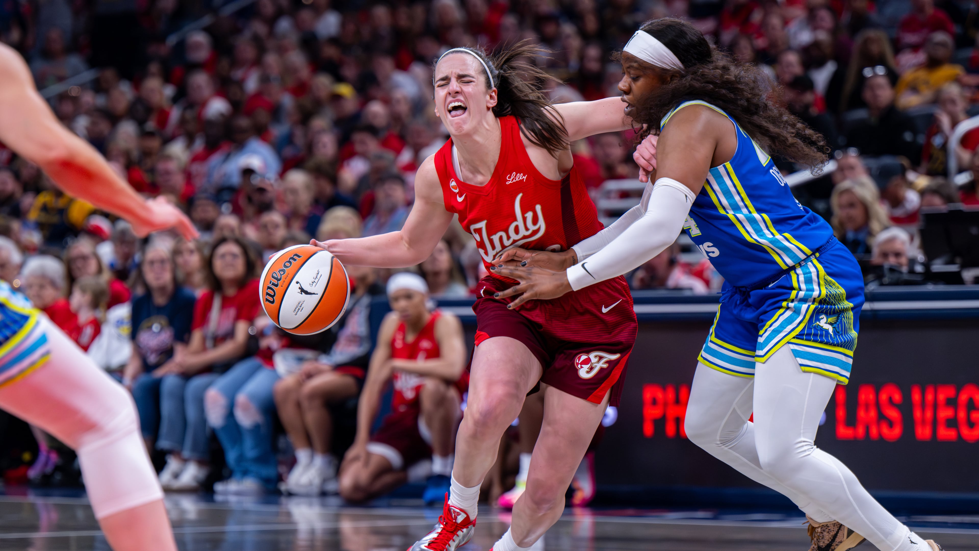 Indiana Fever guard Caitlin Clark (22) reacts as she makes contact with the defense of Dallas Wings guard Arike Ogunbowale (24) during the first half of an WNBA basketball game in Indianapolis, Saturday, May 9, 2026. (AP Photo/Doug McSchooler)