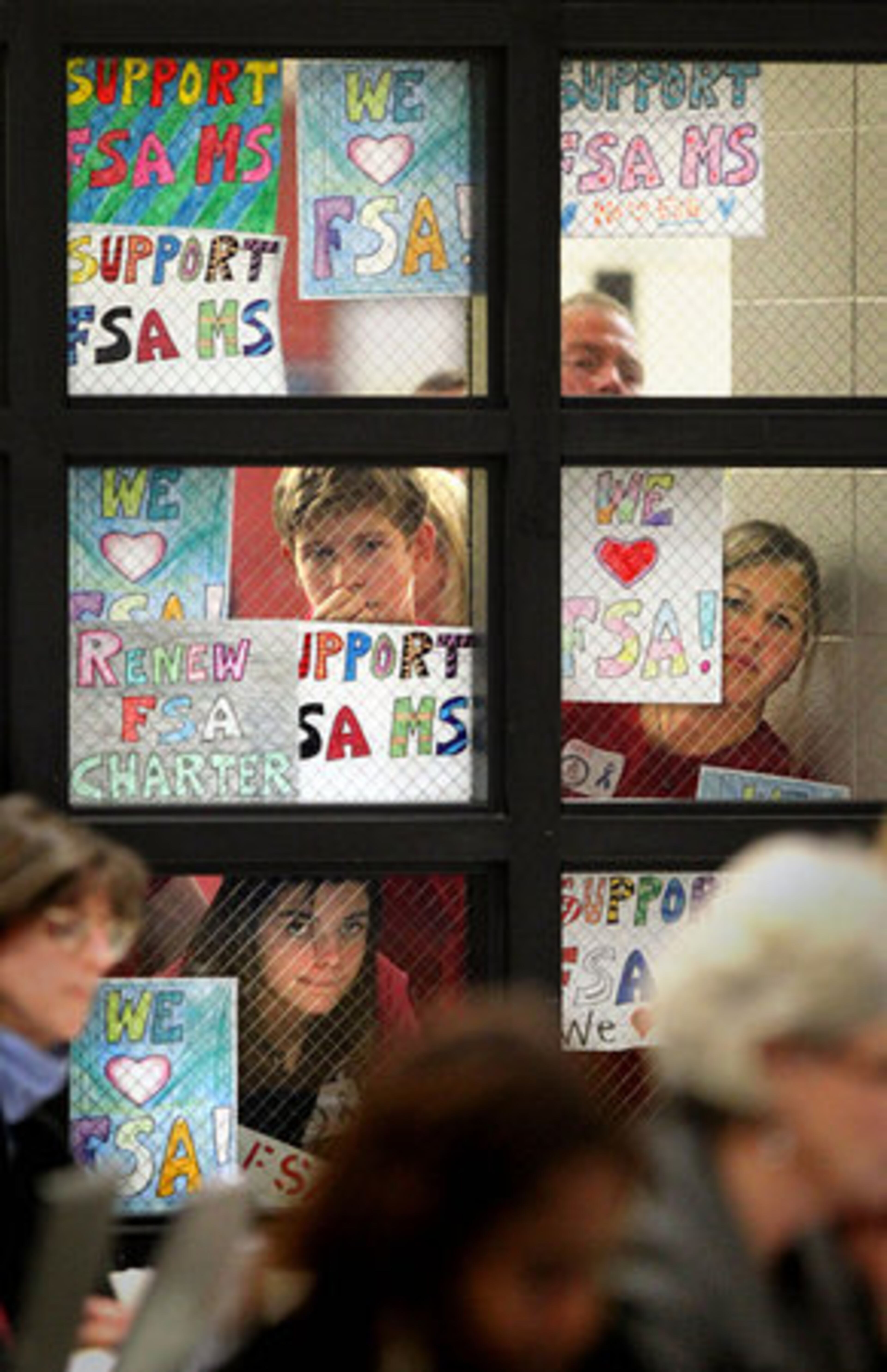 Fulton Science Academy Middle School supporters peer through a window to watch the Fulton County School Board meeting.