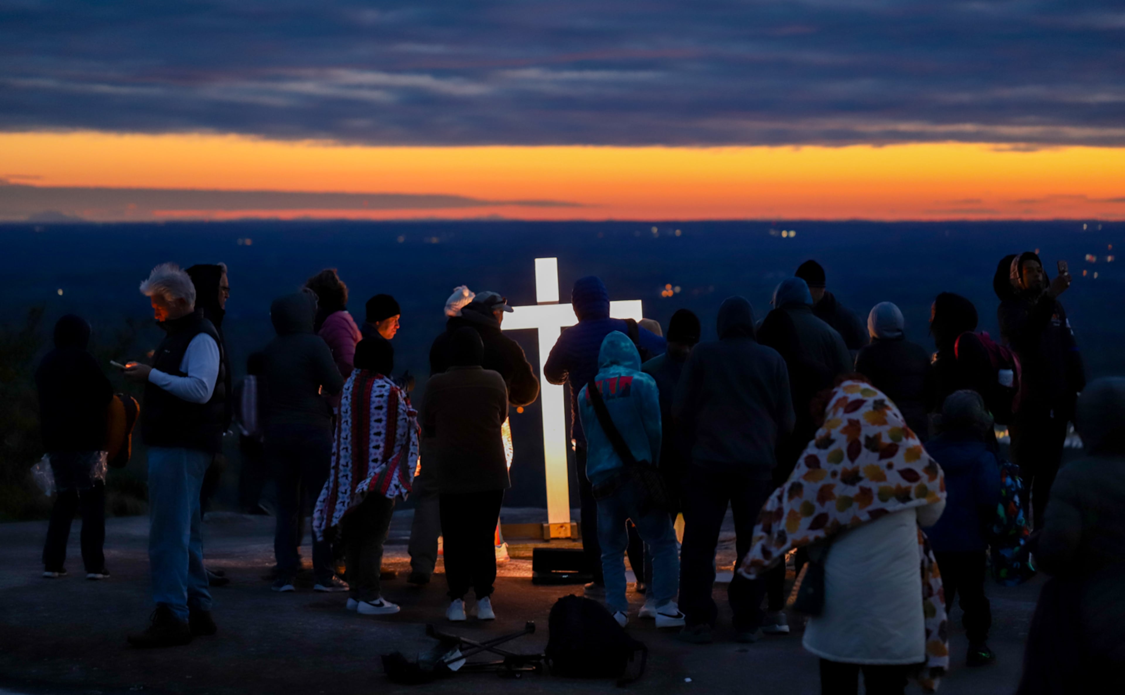 Worshippers gather atop Stone Mountain for the annual Easter sunrise service despite 40 degree weather and 25 mph winds Sunday, April 9, 2023. Thousands ascended Stone Mountain to watch the sun rise over Atlanta and celebrate Easter together. (Photo: Jenni Girtman for The Atlanta Journal-Constitution)