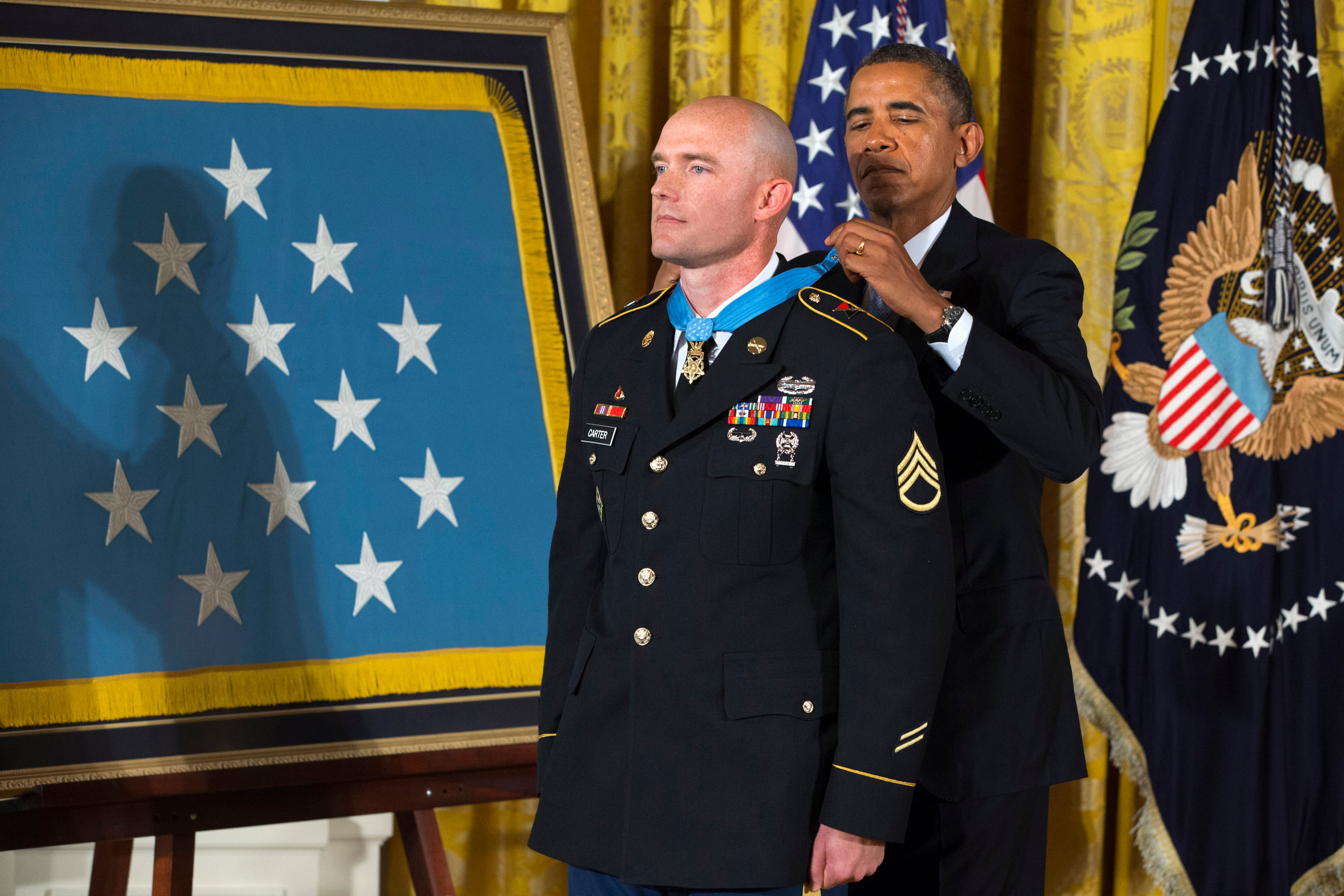 President Barack Obama awards US Army Staff Sgt. Ty M. Carter the Medal of Honor for conspicuous gallantry, Monday, Aug. 26, 2013, during a ceremony in the East Room of the White House in Washington. Carter received the medal for his courageous actions while serving as a cavalry scout with Bravo Troop, 3rd Squadron, 61st Cavalry Regiment, 4th Brigade Combat Team, 4th Infantry Division, during combat operations in Kamdesh District, Nuristan Province, Afghanistan on Oct. 3, 2009. Carter is the fifth living recipient to be awarded the Medal of Honor for actions in Iraq or Afghanistan. (AP Photo/Jacquelyn Martin)