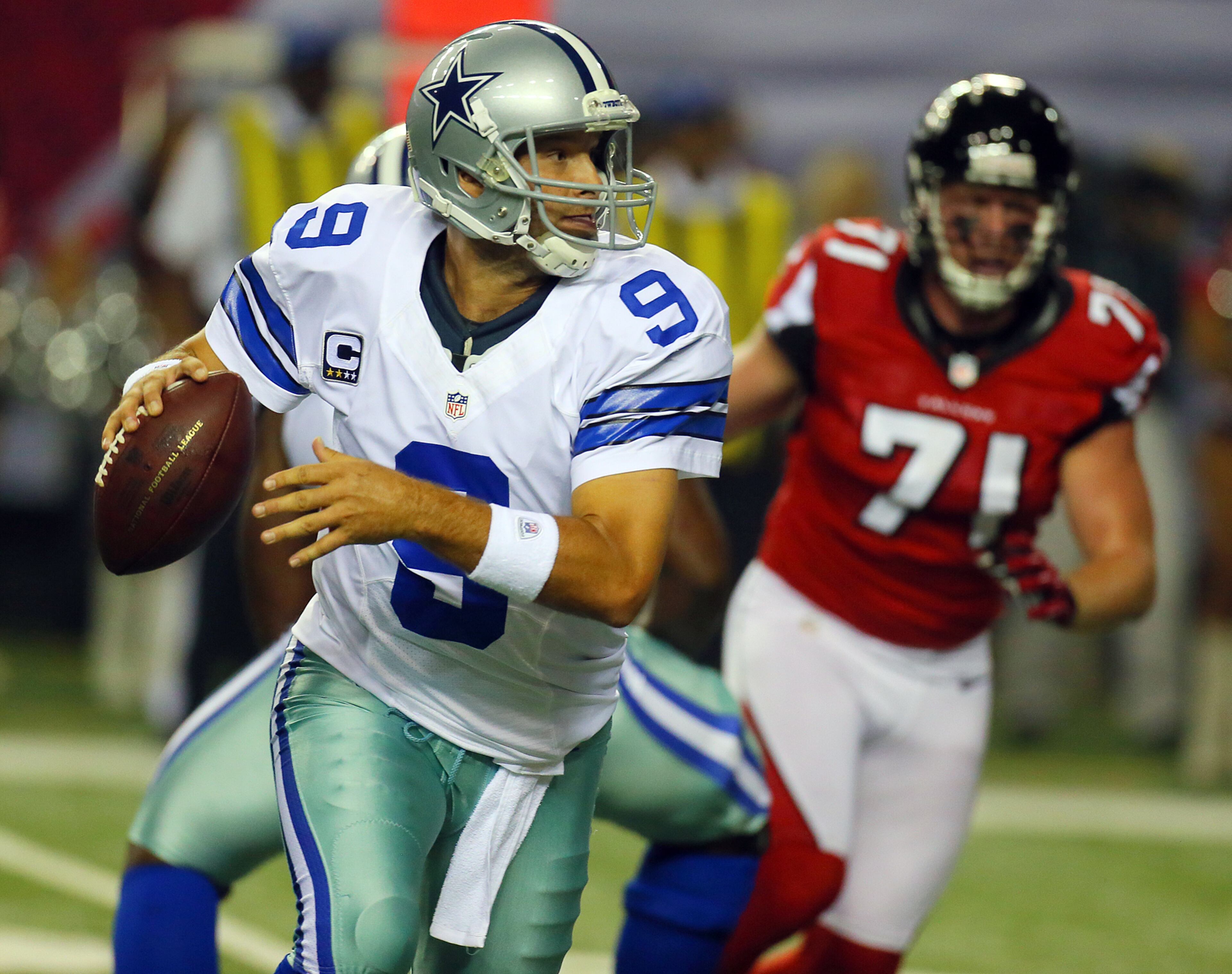 Cowboys quarterback Tony Romo rolls out to pass under pressure from Falcons defensive end Kroy Bierman during 1st half action at the Georgia Dome in Atlanta on Sunday, Nov. 4, 2012. CURTIS COMPTON / CCOMPTON@AJC.COM
