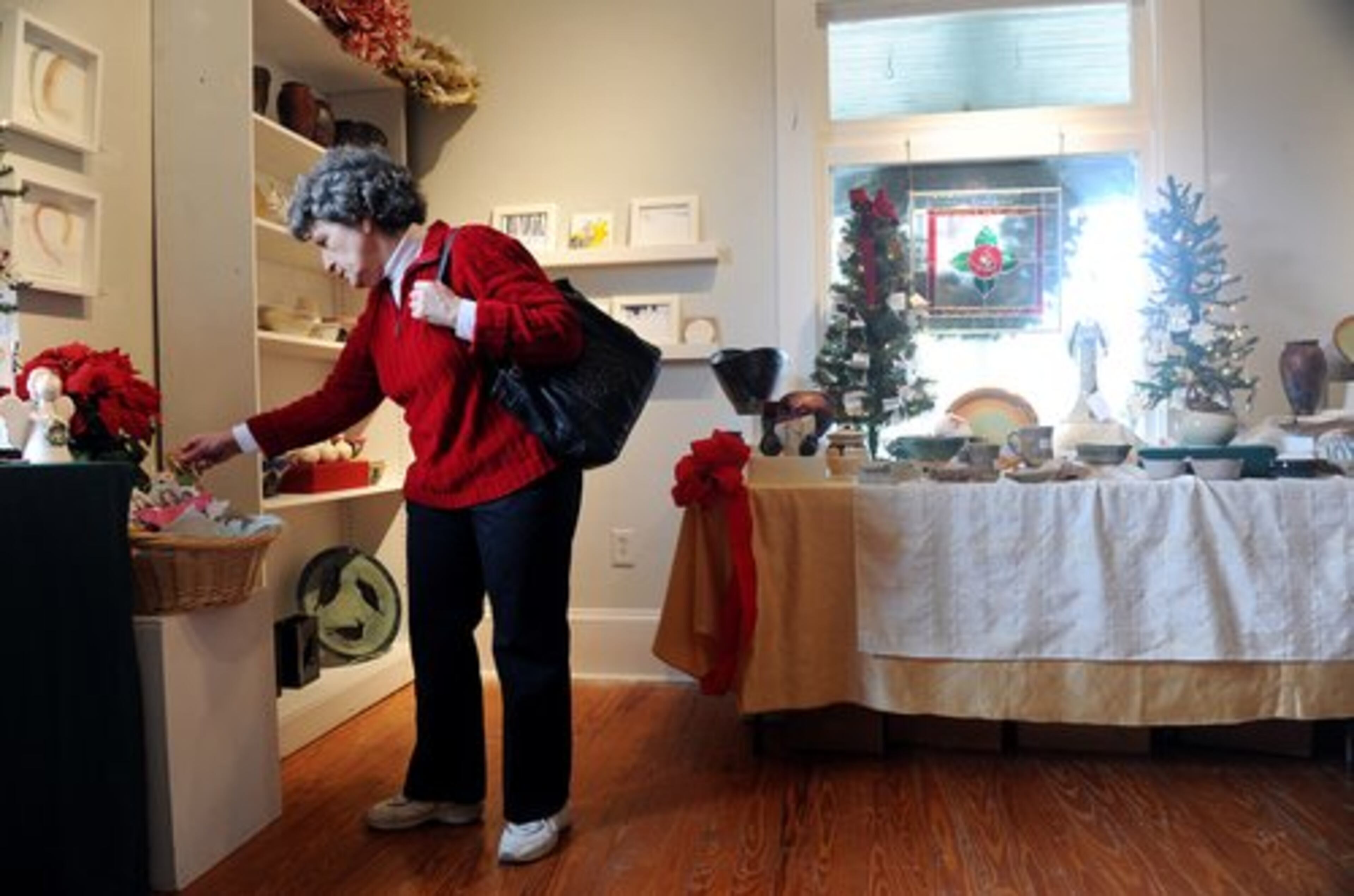 Gail Crider of Dunwoody checks out ornaments for sale at the Holiday Artists Market at the Spruill Center for the Arts in Dunwoody.