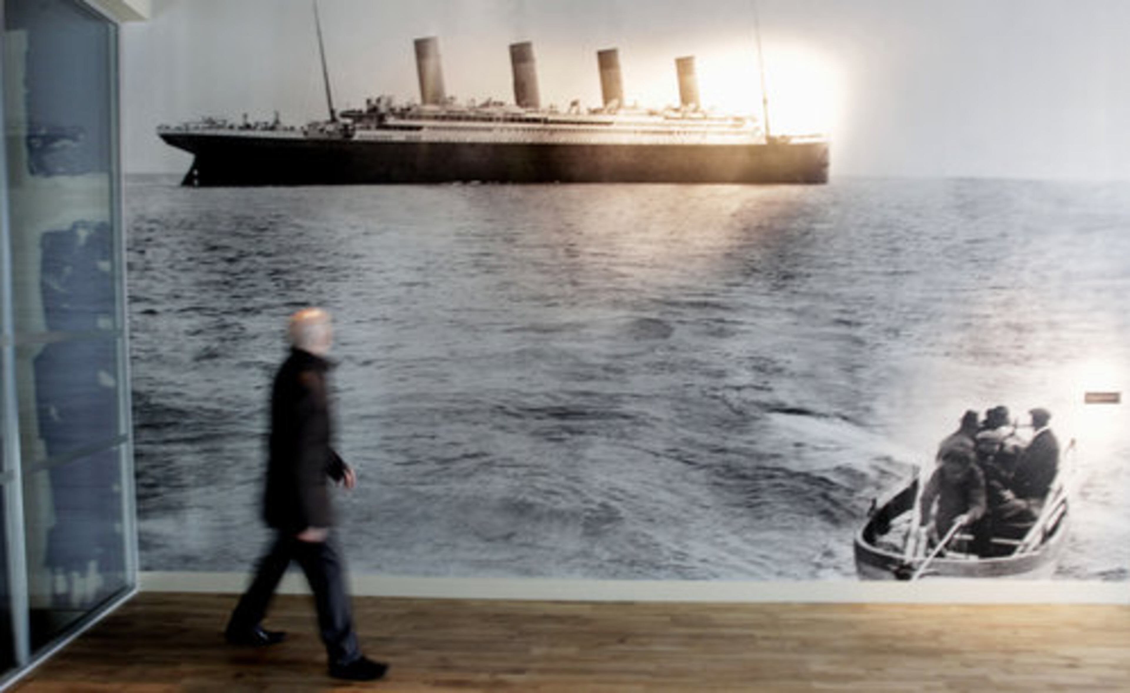 A man walks past the last picture of the Titanic taken off the coast of Cork in Ireland, on display in the new $157 million Titanic Belfast Visitor's Center, in Belfast, Northern Ireland. Celebrating the ship and the people who built her is the aim of Titanic Belfast, a shiny new "visitor experience" _ don't call it a museum _ whose four prow-like wings jut jauntily skyward beside the River Lagan on the site of the old Harland and Wolff shipyard.