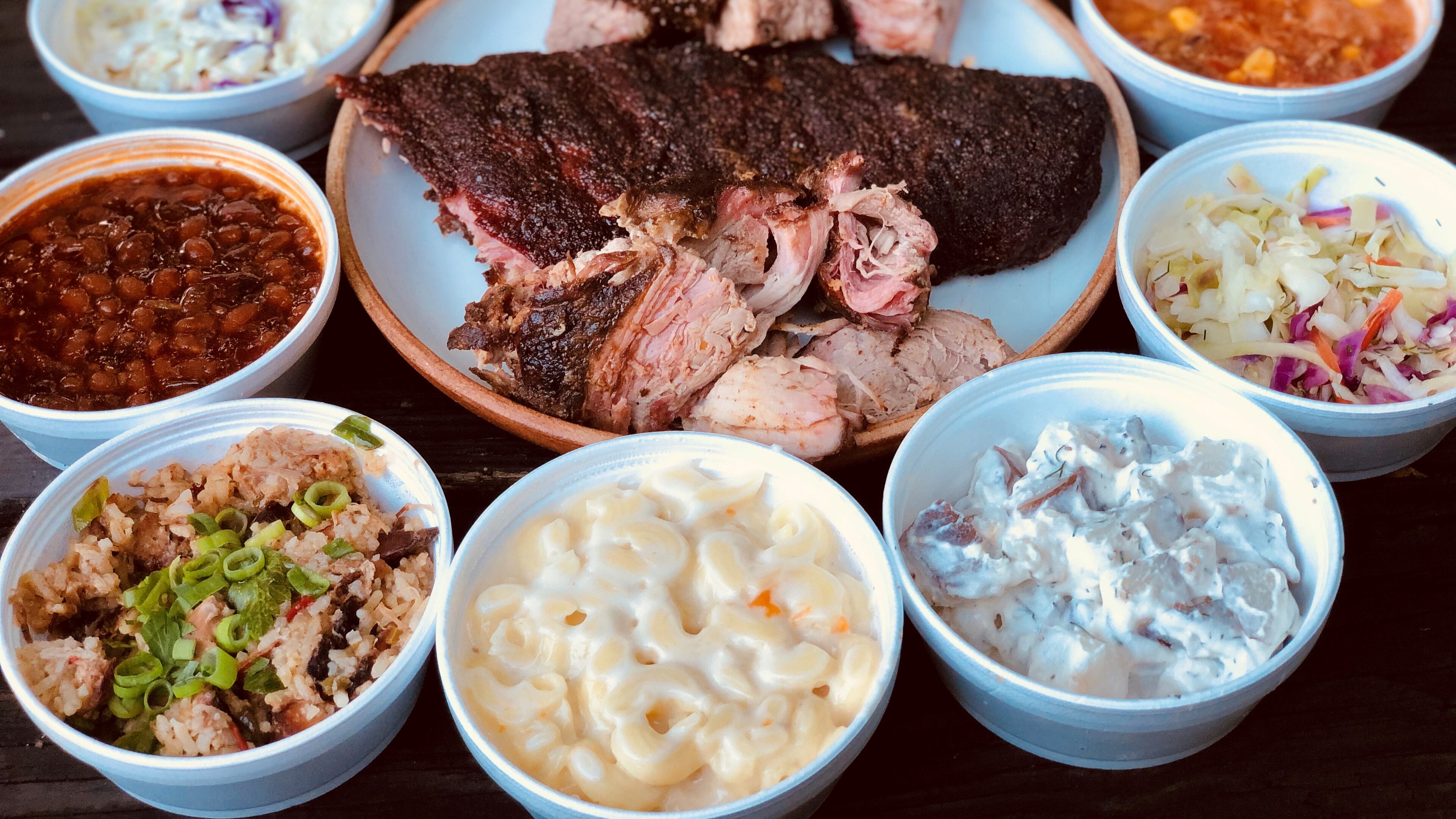 Takeout from Taylor’d Bar-B-Q includes brisket, ribs, pulled pork, plus all the fixings (clockwise from top): tots, Brunswick stew, vinegar slaw, potato salad, mac and cheese, Jambalaya Que, baked beans and creamy cole slaw. CONTRIBUTED BY WENDELL BROCK