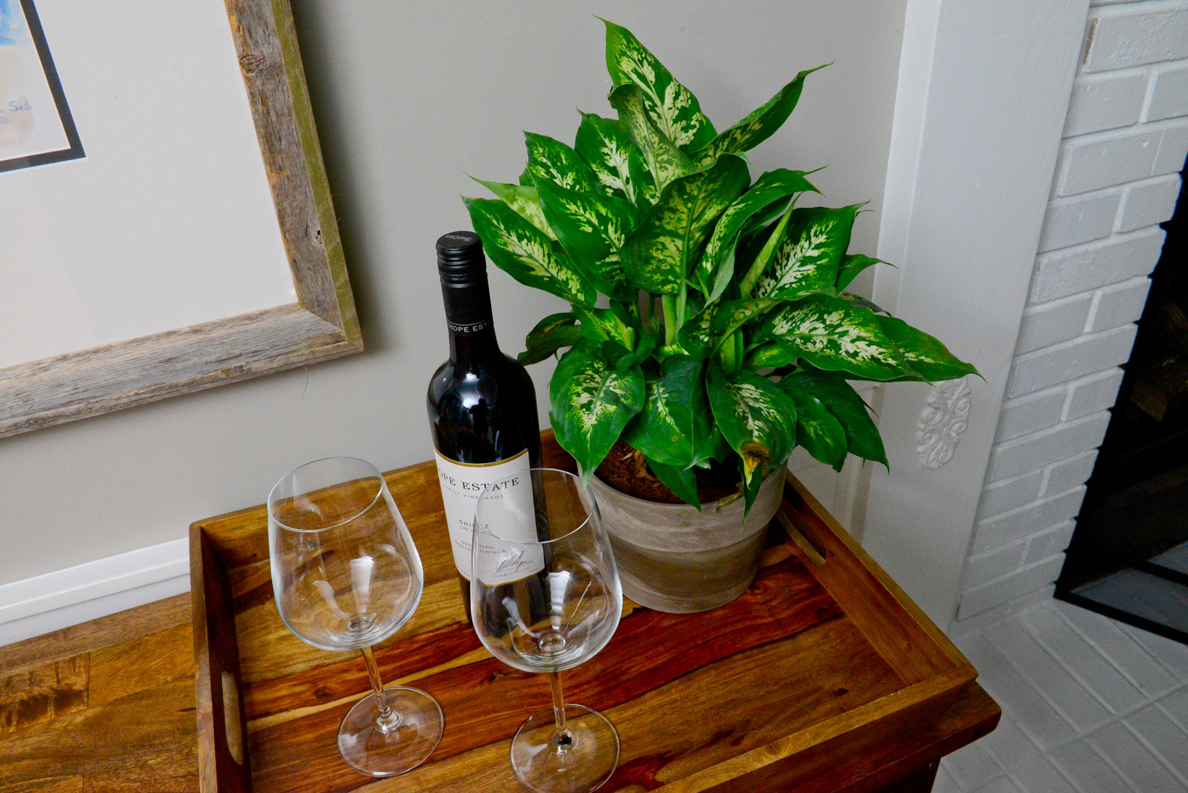 Two console tables from World Market - also on casters for easy movement - fill in the spaces on both sides of the fireplace. A wood tray serves a spot for a potted plant or for serving drinks.