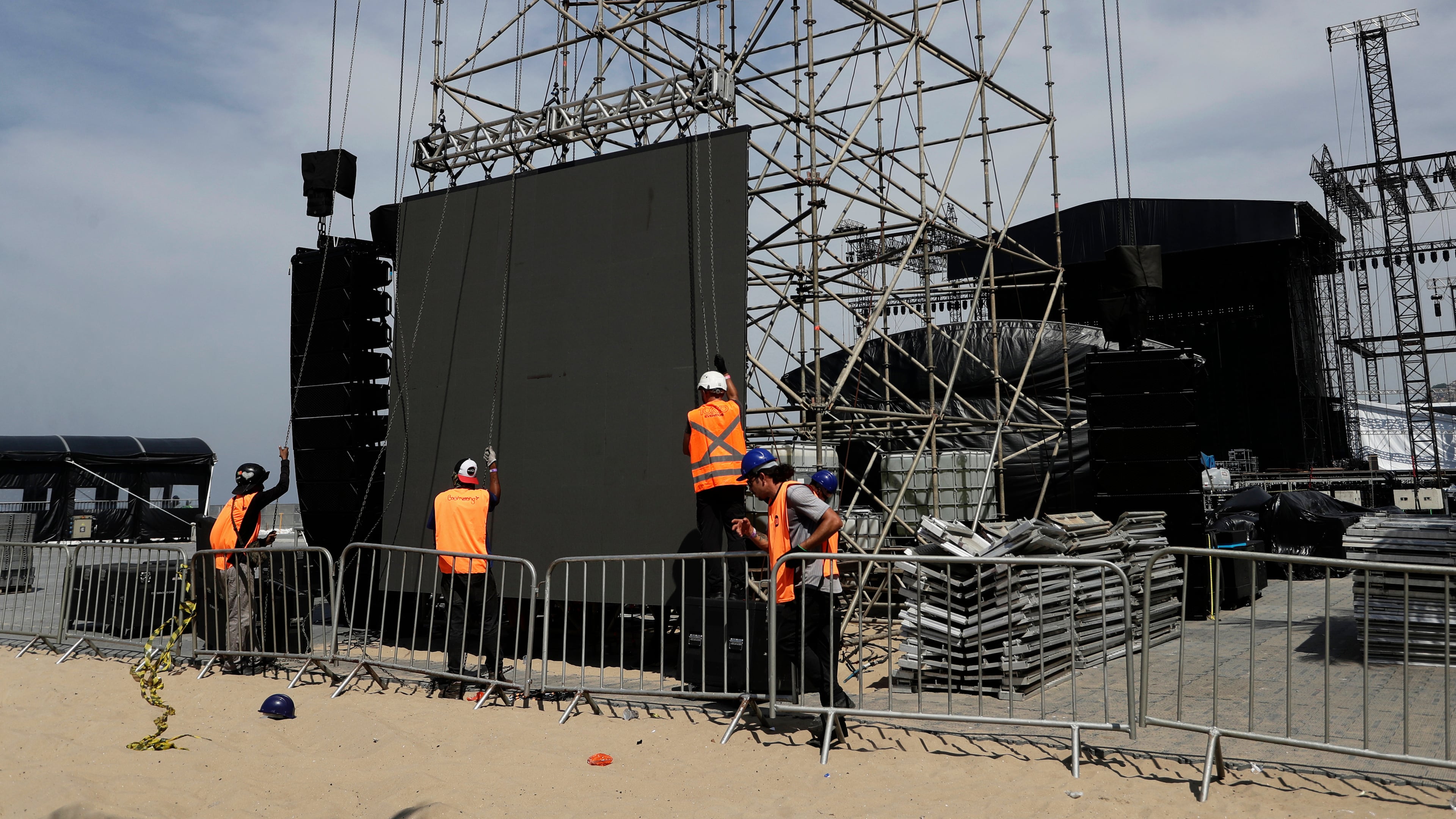Workers resume construction on the stage for a concert by Colombian pop star Shakira after the death of a worker in an accident during setup a day prior, at Copacabana beach in Rio de Janeiro, Monday, April 27, 2026. (AP Photo/Bruna Prado)