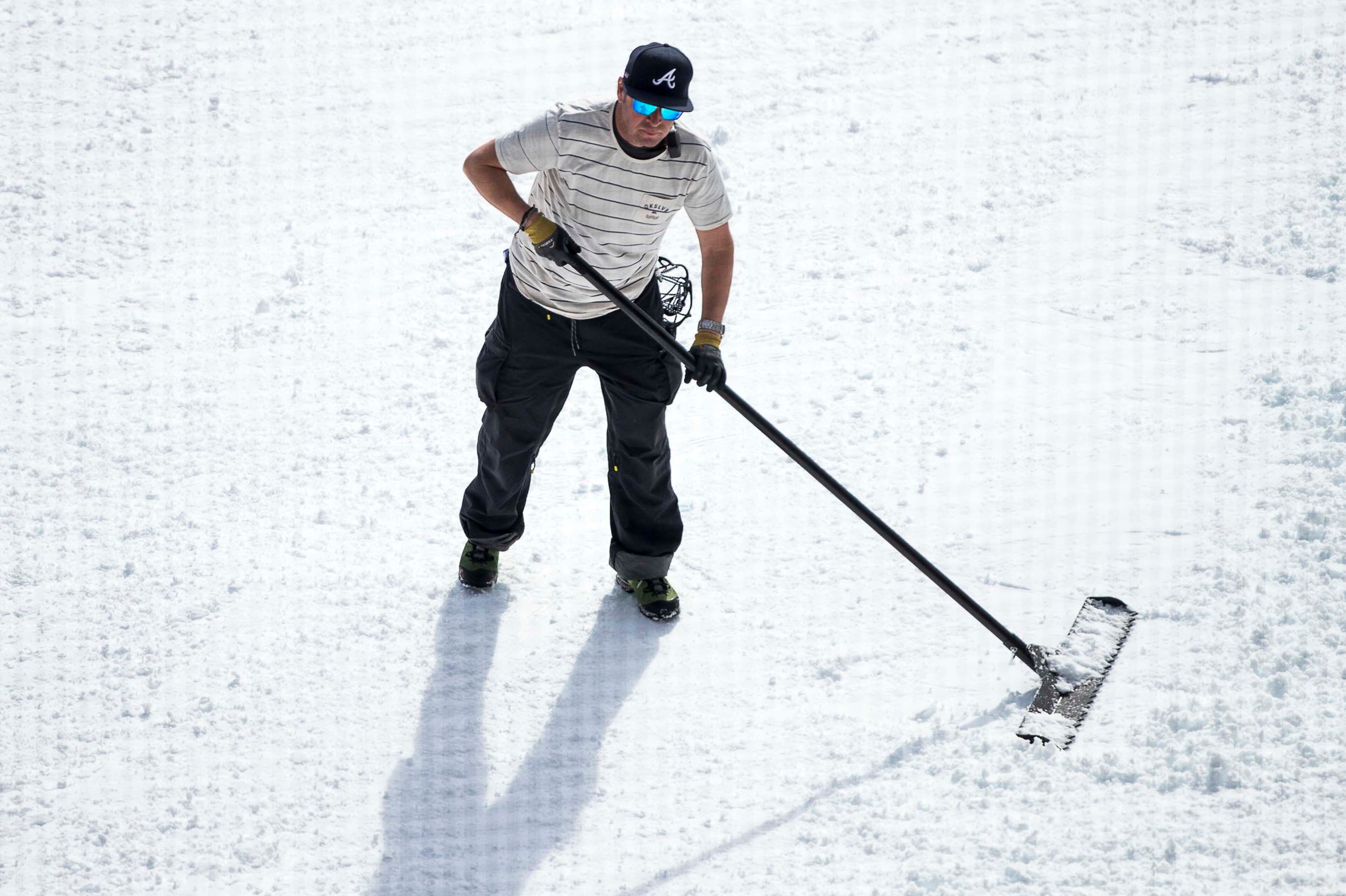 Before the start of the second qualifying heat of the men's snowboard competition, a worker tends to the snow at the bottom of the ski-slope at SunTrust Park in Atlanta on Friday, December 20, 2019. (ALYSSA POINTER/ALYSSA.POINTER@AJC.COM)