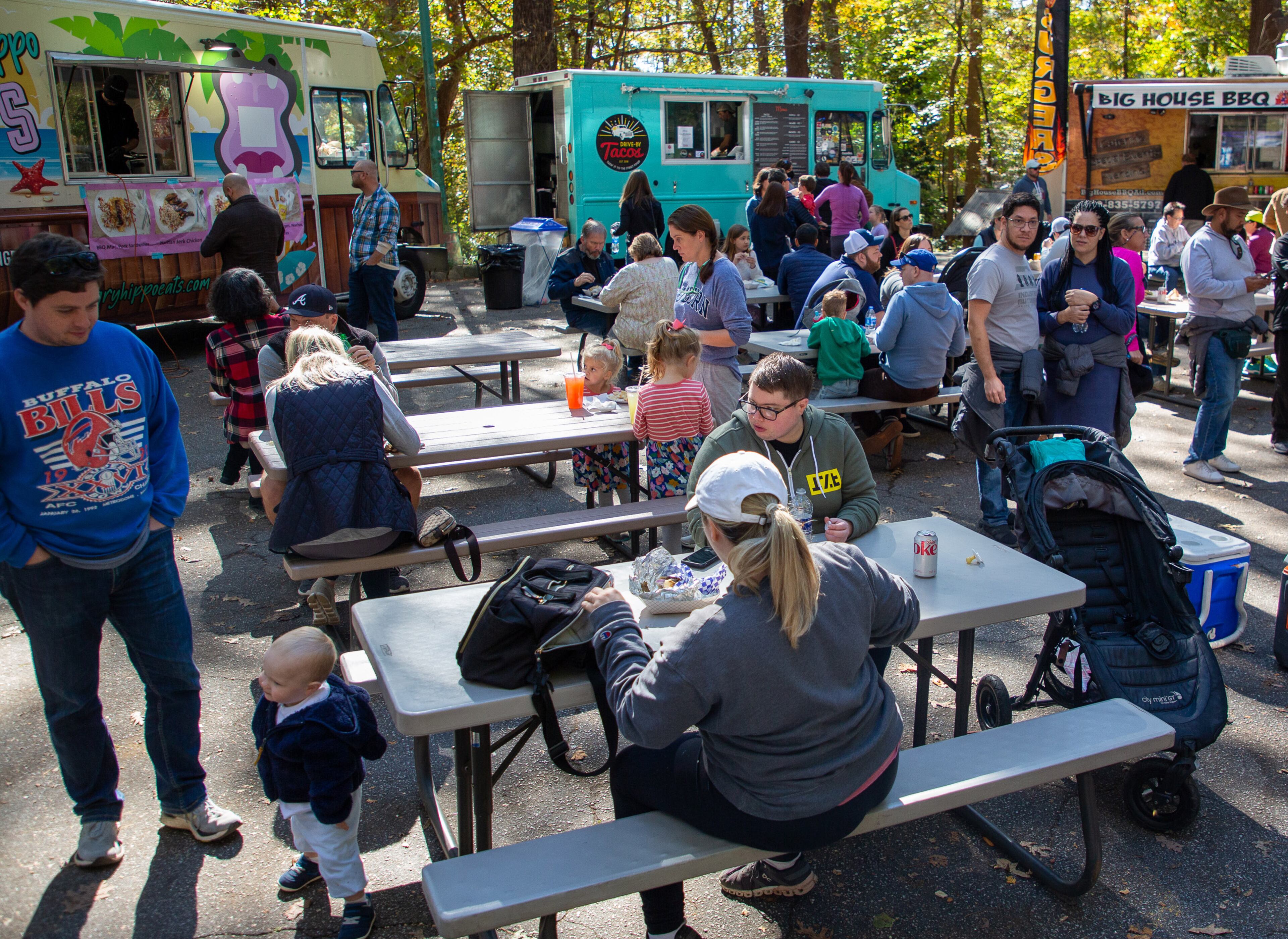 People enjoy their lunch from the food trucks during the Chastain Park Fall Arts Festival on Sunday, November 7, 2021. STEVE SCHAEFER FOR THE ATLANTA JOURNAL-CONSTITUTION