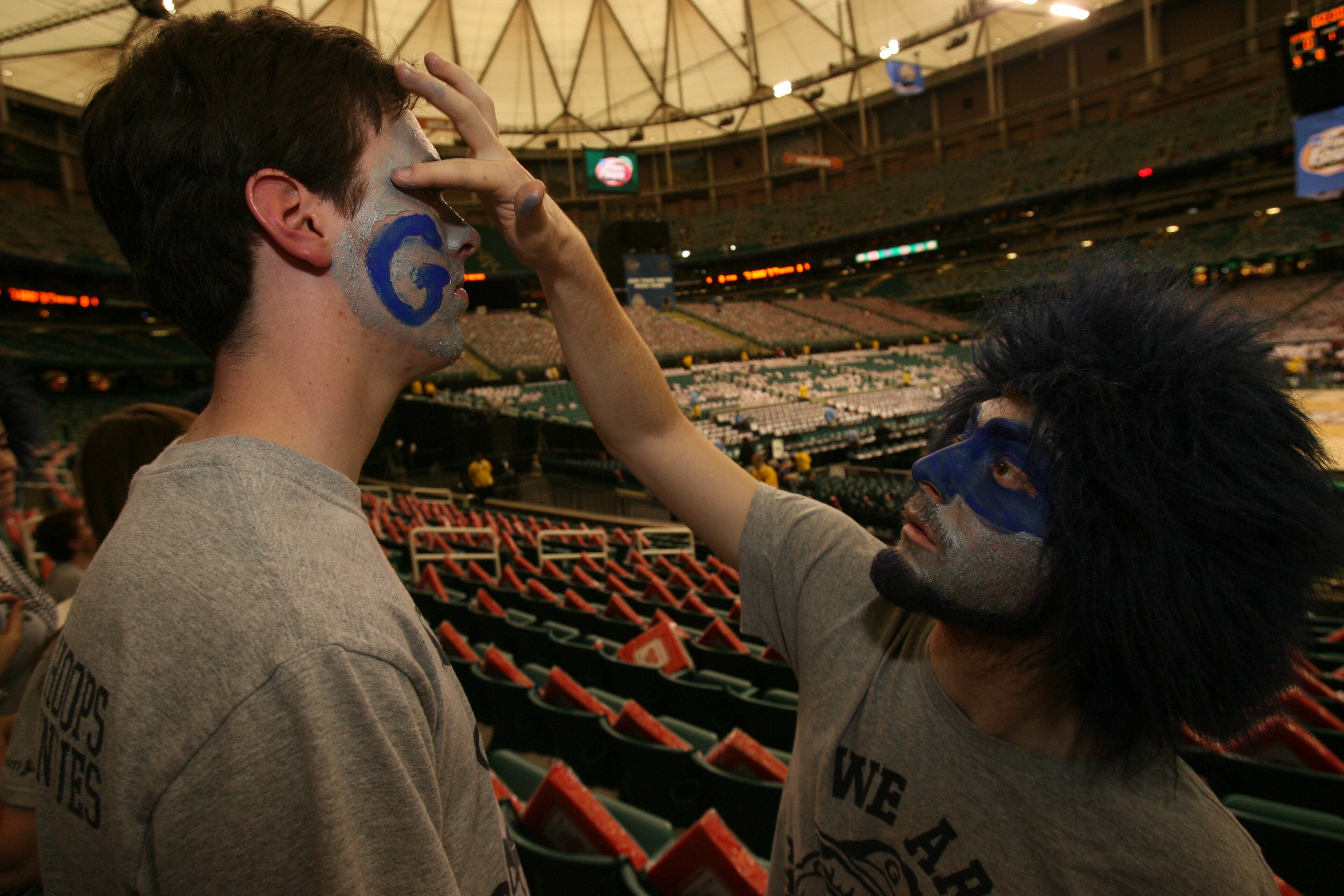 Georgetown fan Brad Anderson getting his face painted by Nick Sementelli Saturday March 31, 2007 prior to game one of the Final Four semi-final game between Ohio State and Georgetown.