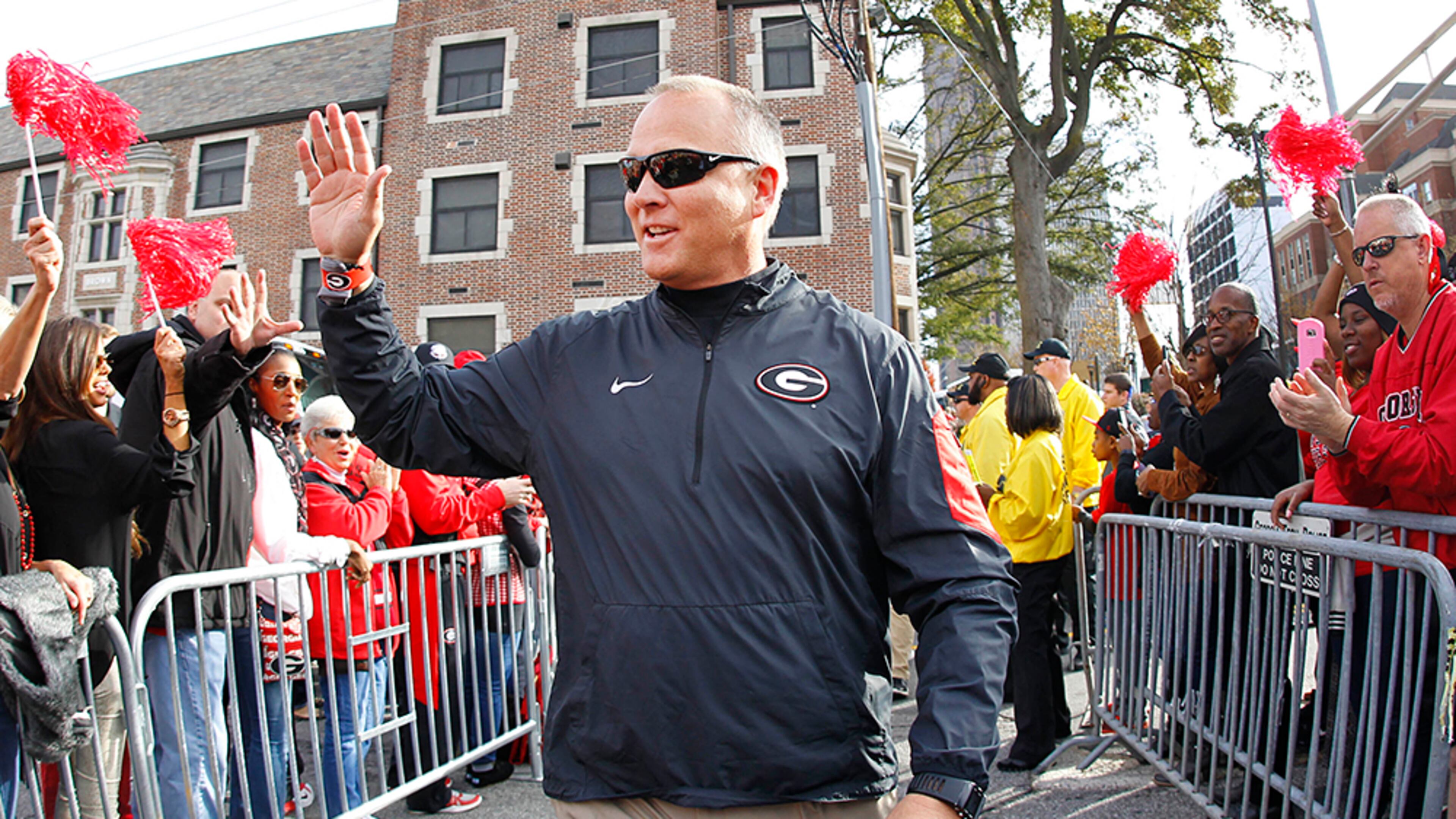 Georgia head coach Mark Richt greets the crowd during the "Dog Walk" as he and his team arrive for an NCAA college football game against Georgia Tech, Saturday, Nov. 28, 2015, in Atlanta, Ga. (AP Photo/Brett Davis)