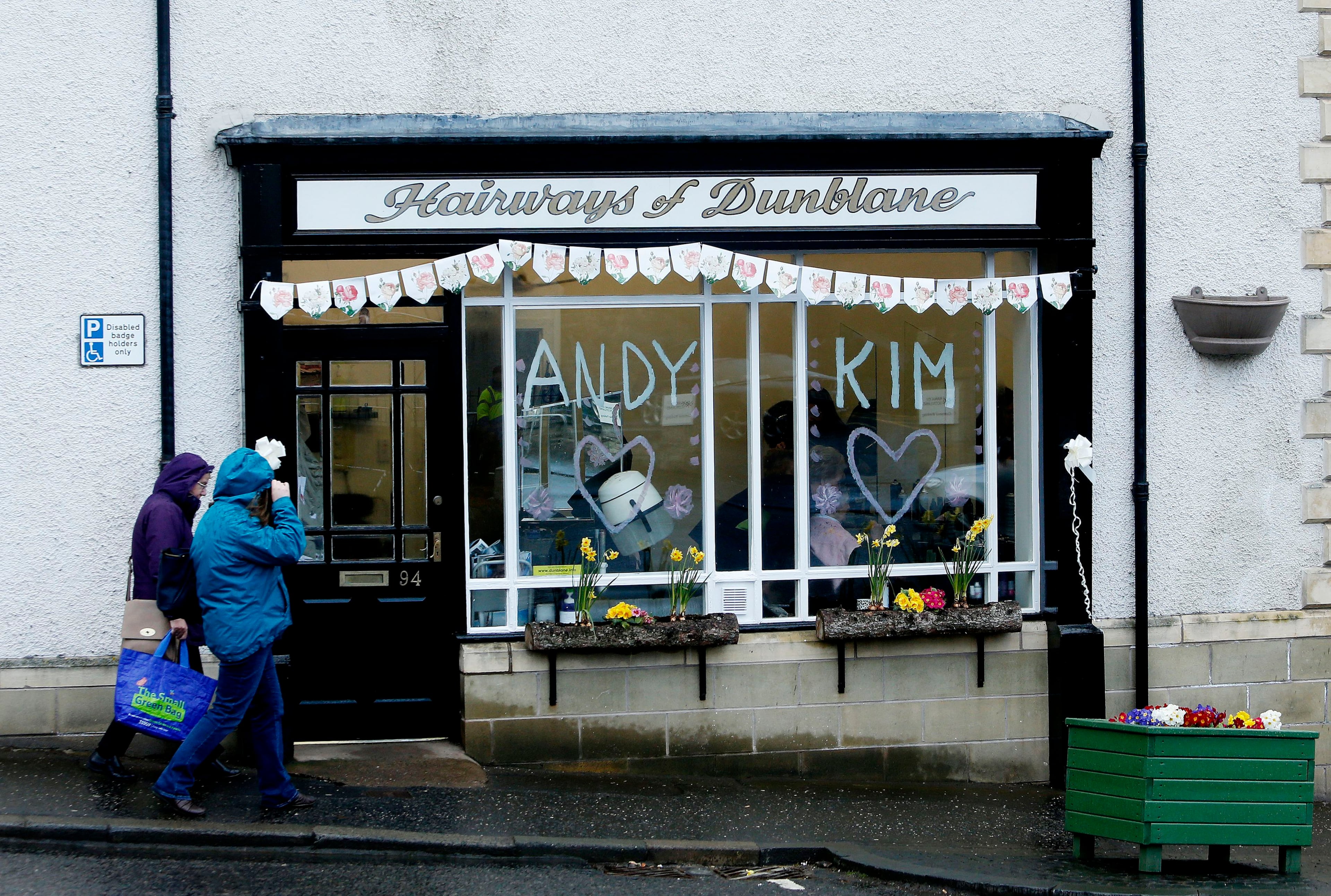 People walk past a hairdresser's window in Dunblane, Scotland, with the names of British tennis number one Andy Murray and his long-term girlfriend Kim Sears, who will get married at Dunblane Cathedral in his home town later Saturday, April 11, 2015. (AP Photo/PA, Danny Lawson) UNITED KINGDOM OUT NO SALES NO ARCHIVE