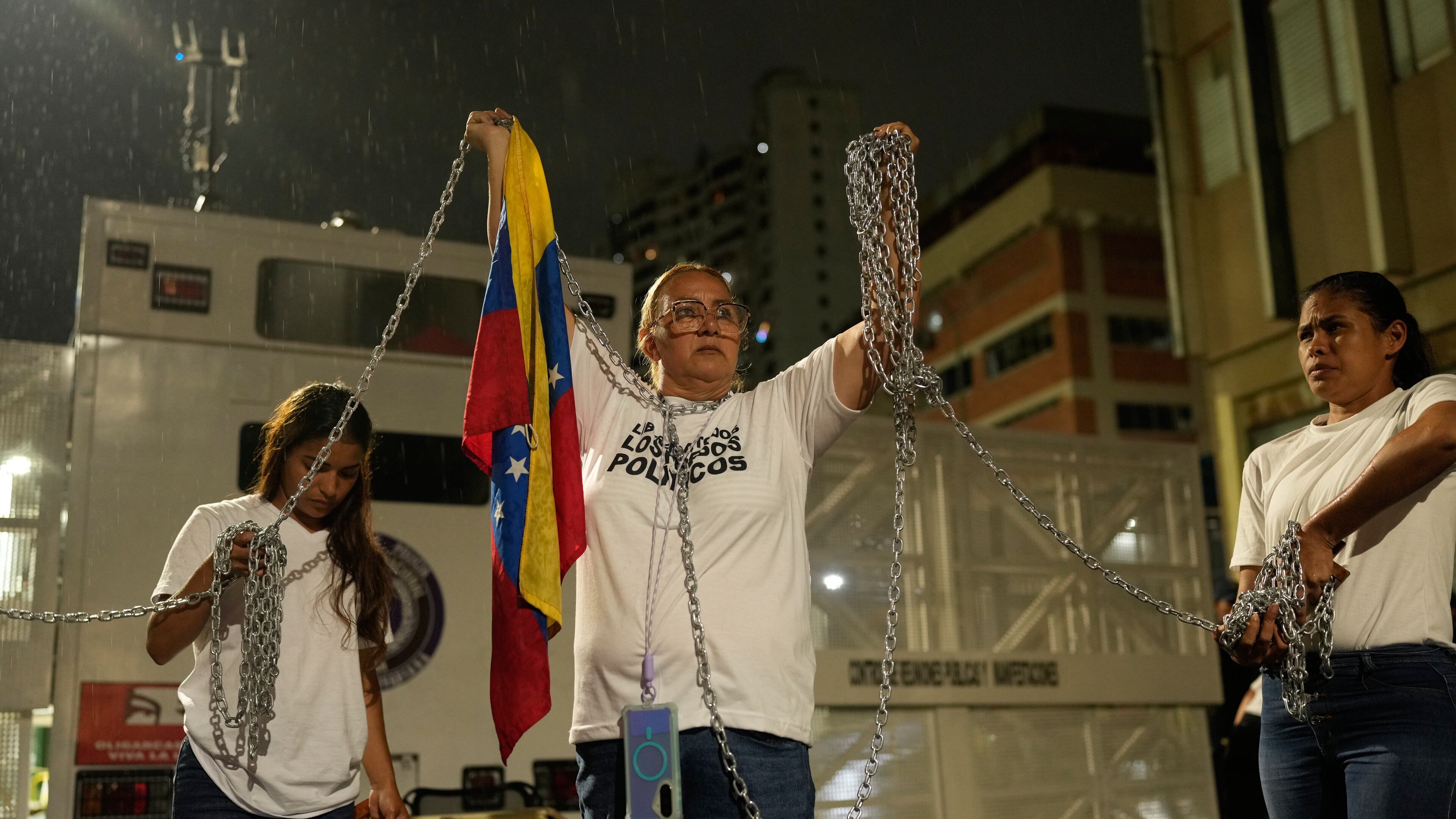 Relatives of people they consider to be detained for political reasons protest holding chains in front of police guarding the Zona 7 Bolivarian National Police detention center in Caracas, Venezuela, Friday, Jan. 30, 2026, on the same day acting President Delcy Rodríguez announced an amnesty bill that could lead to the release of hundreds of prisoners, including opposition leaders, journalists and human rights activists detained for political reasons. (AP Photo/Ariana Cubillos)