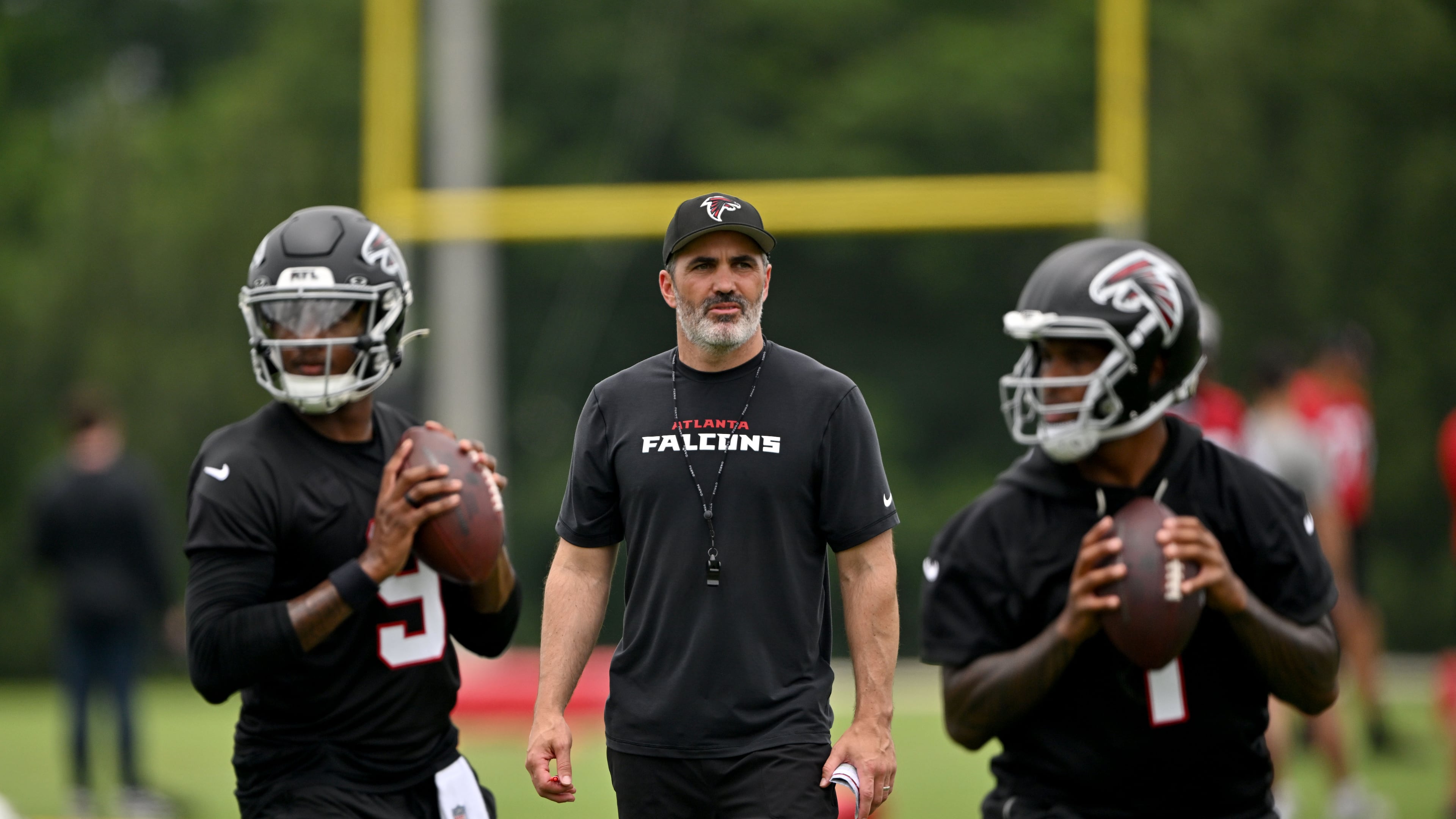 Atlanta Falcons head coach Raheem Morris watches as quarterback Michael Penix Jr. (left) and quarterback Tua Tagovailoa (right) run drills during an OTA workout at Atlanta Falcons Training Facility on Wednesday, May 27, 2026, in Flowery Branch. (Hyosub Shin/AJC)