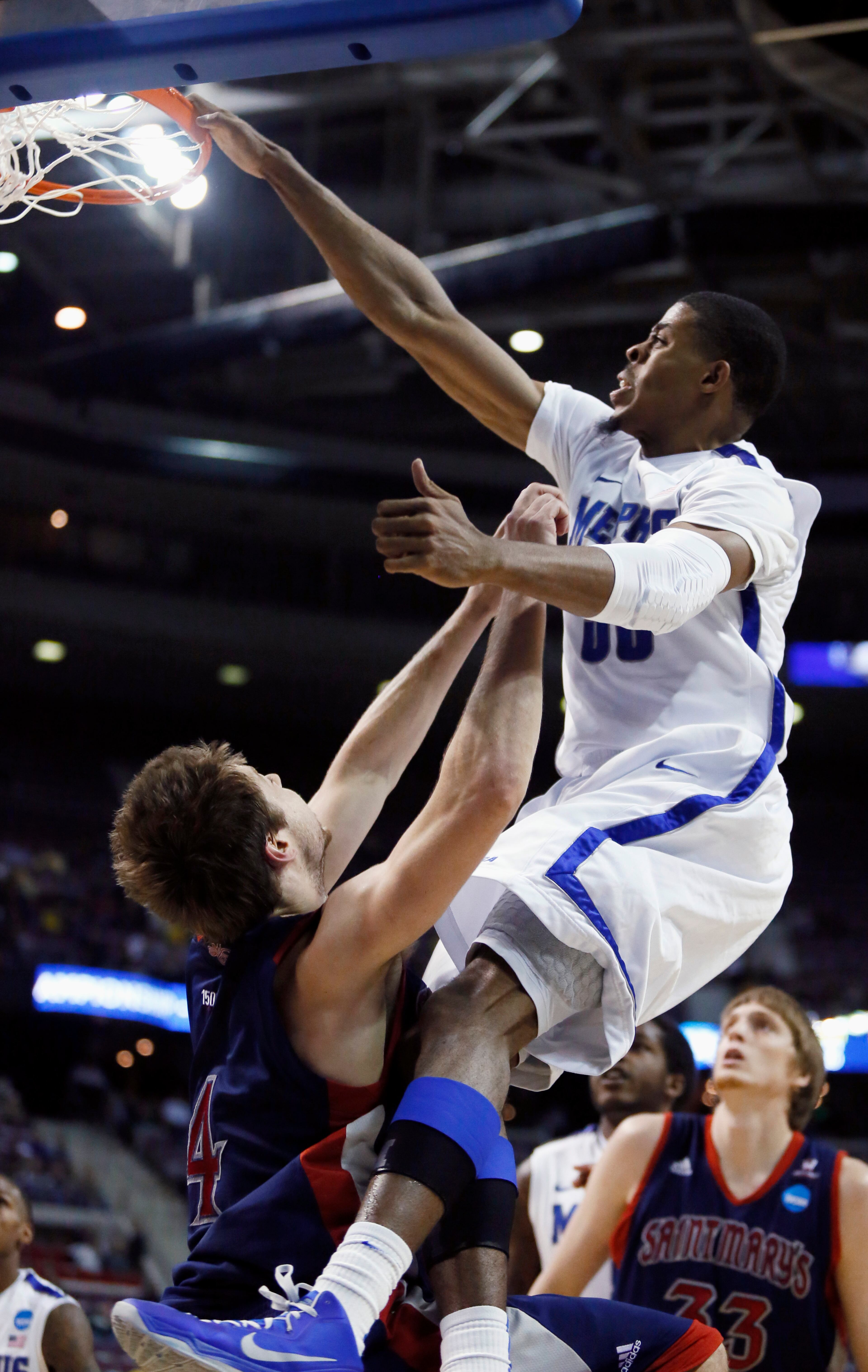 Memphis guard D.J. Stephens (30) dunks over Saint Mary's guard Matthew Dellavedova (4) during the second half of a second-round game of the NCAA college basketball tournament Thursday, March 21, 2013, in Auburn Hills, Mich. Memphis defeated Saint Mary's 54-52. (AP Photo/Duane Burleson)