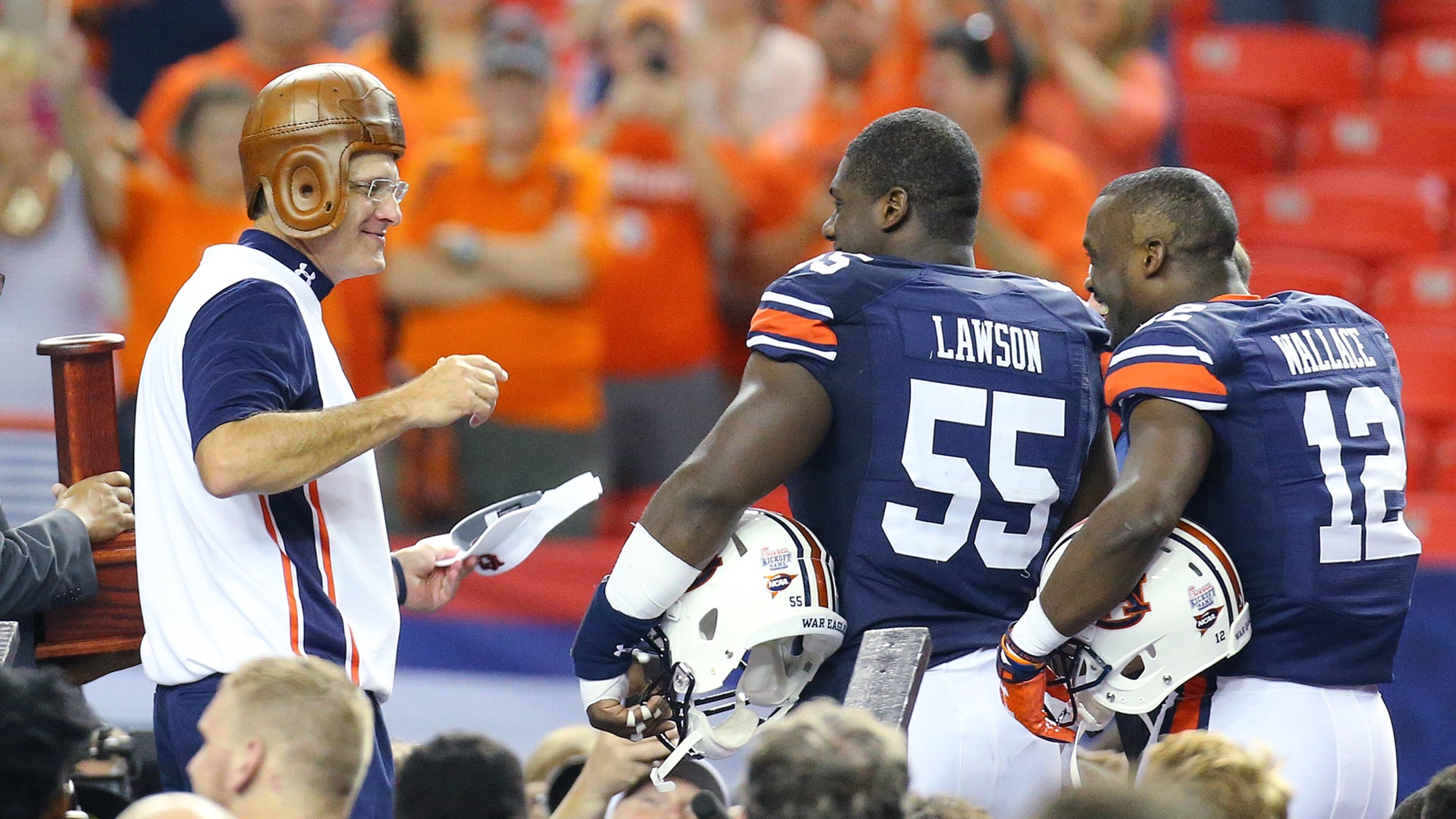 090515 ATLANTA: Auburn head coach Gus Malzahn (from left) shares a laugh with Carl Lawson and Jonathan Wallace as he puts on the "leather helmet" trophy winning the Chick-fil-A Kickoff Game 31-24 over Louisville on Saturday, Sept. 5, 2015, in Atlanta. Curtis Compton / ccompton@ajc.com