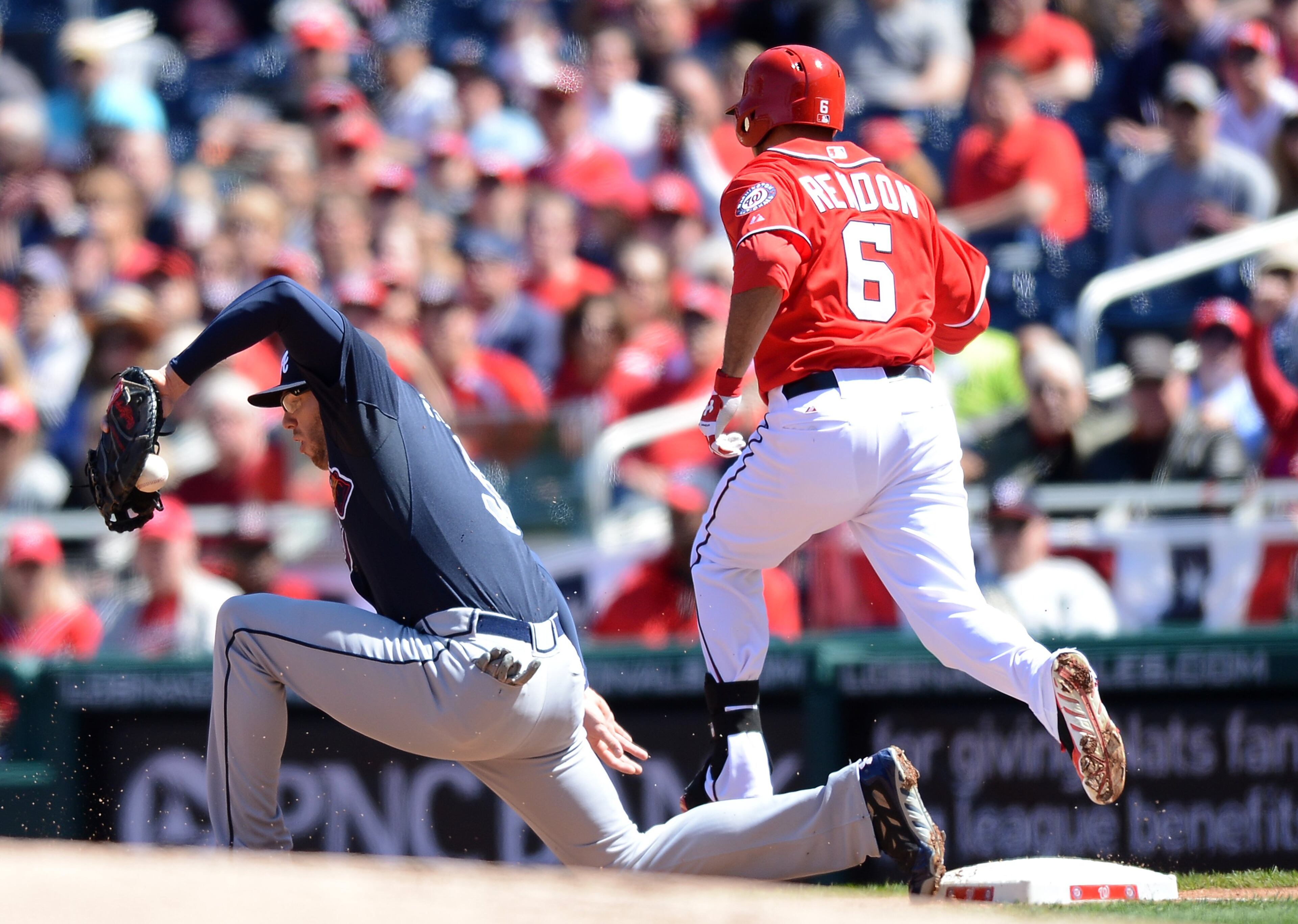 Washington Nationals third baseman Anthony Rendon (6) beats out a bunt single throw to Atlanta Braves first baseman Freddie Freeman (5) in the first inning at Nationals Park in Washington, D.C., Sunday, April 6, 2014. (Chuck Myers/MCT)