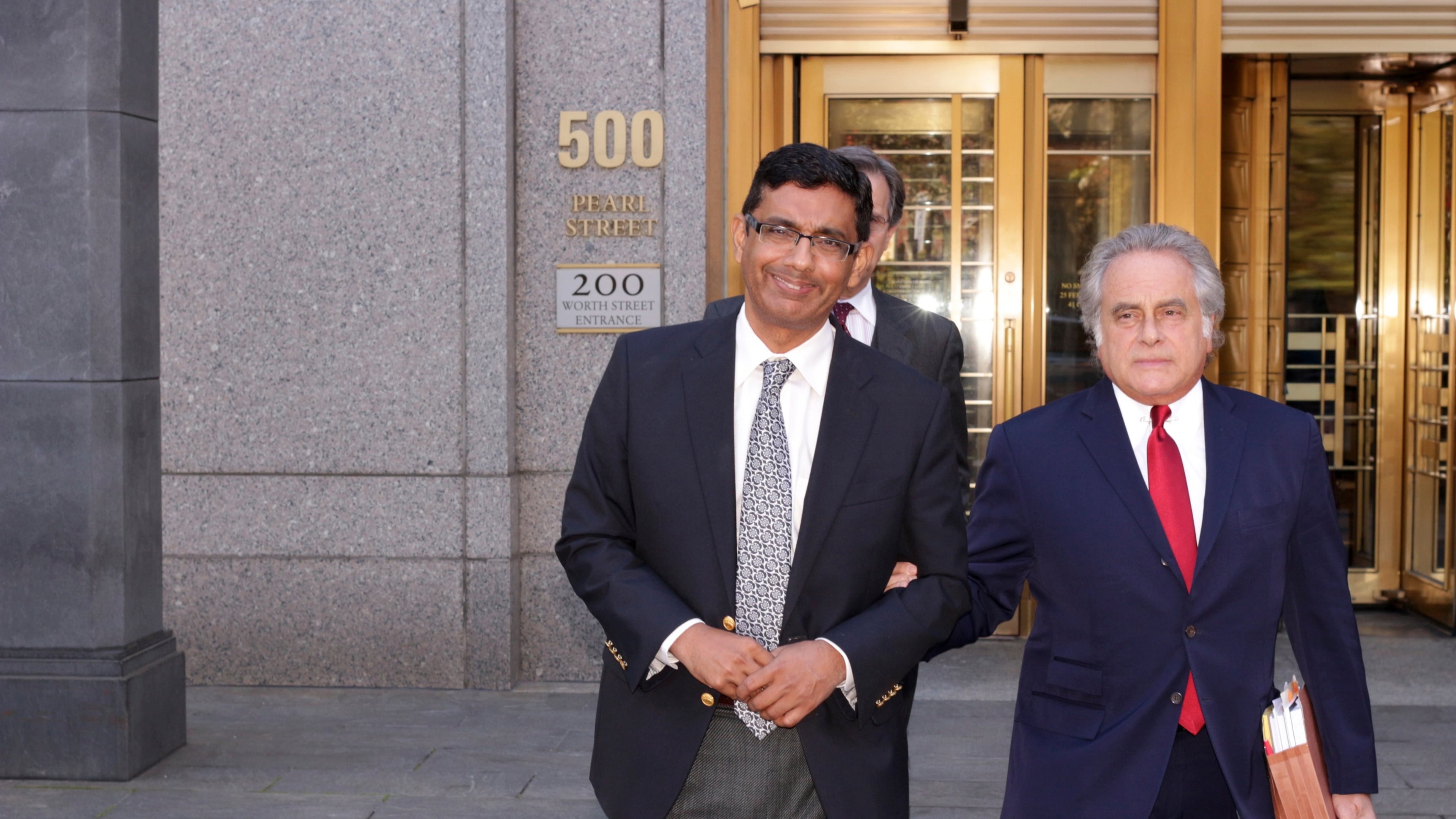 Dinesh D'Souza (left), a conservative commentator and documentarian, is photographed after his sentencing for a campaign finance violation in New York in 2014. Four years later he was issued a pardon by President Donald Trump.