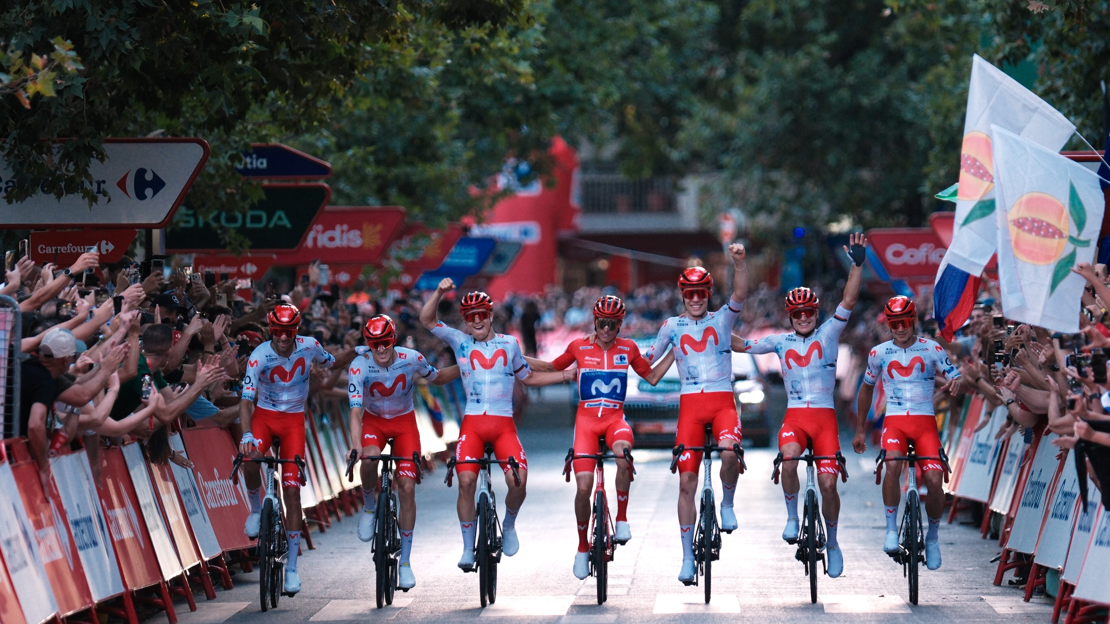 Spain's Enric Mas, center, flanked by his teammates, crosses the finish line during the 21st stage of the Spanish Vuelta cycling race, from Carrefour Granada to Granada, Spain, Sunday, Sept. 13, 2026. (AP Photo/Gregorio Marrero)