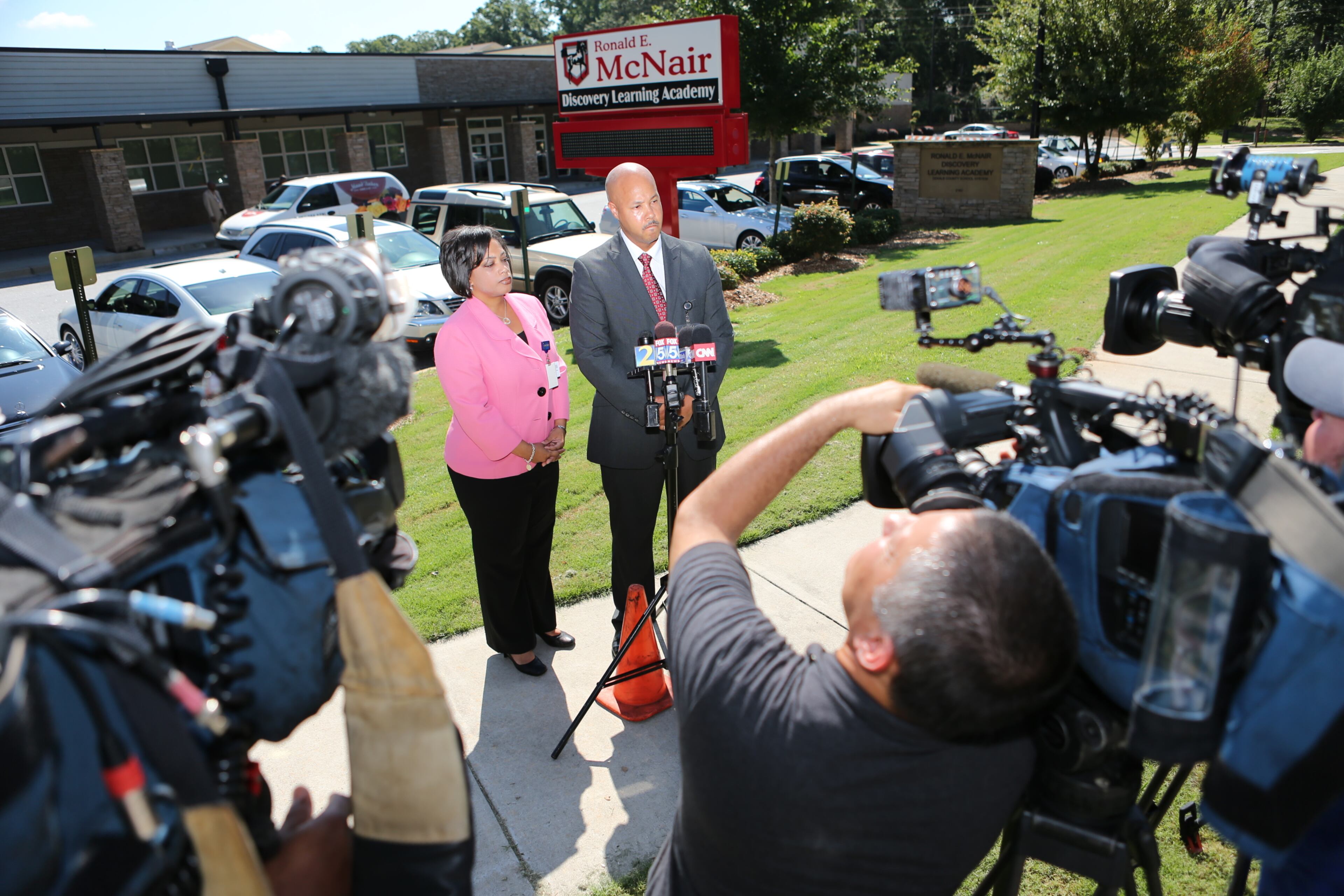 McNair principal Brian Bolden and DeKalb schools counselor Vasanne Tinsley hold a press conference as students return to campus.