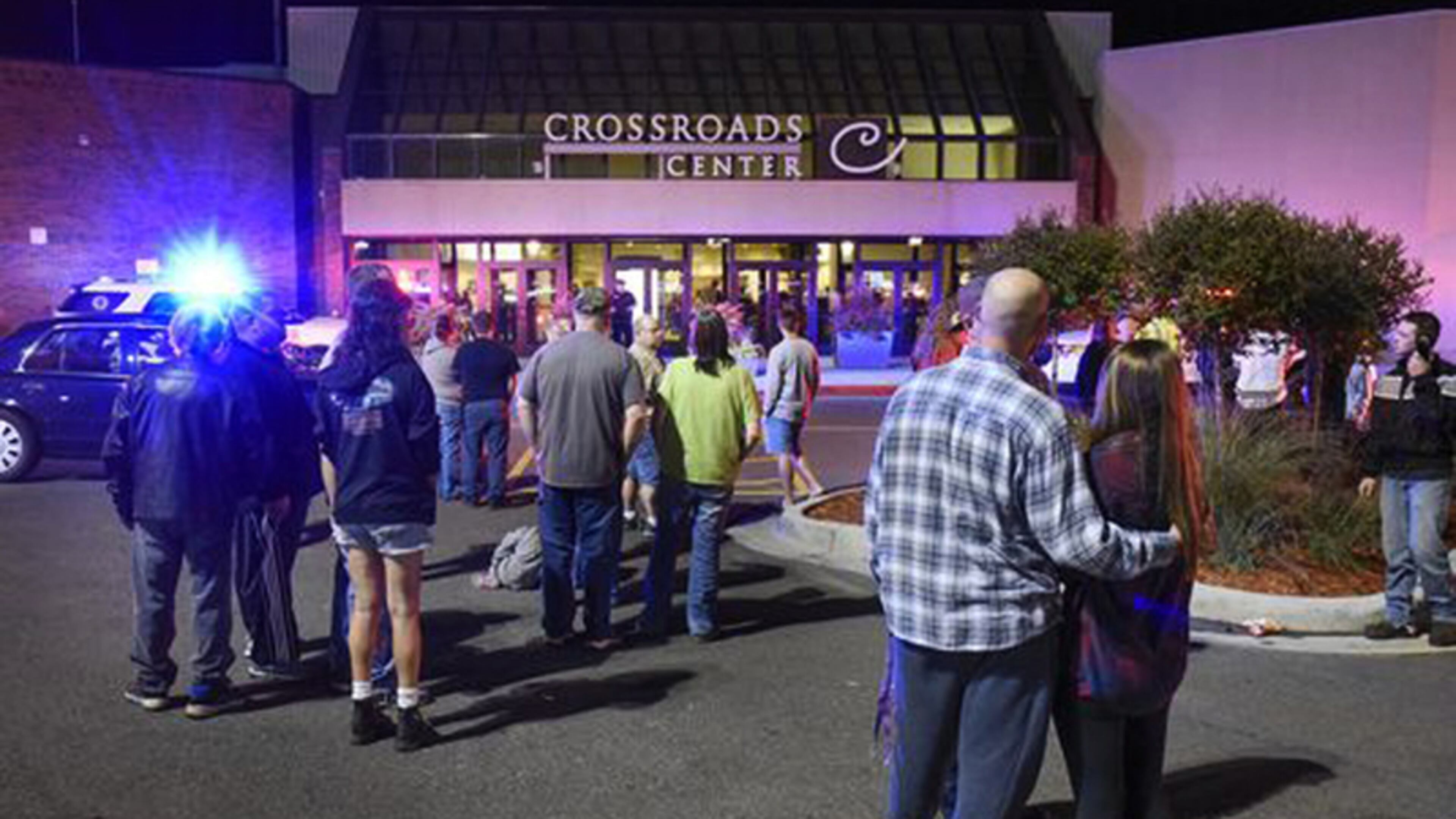 People stand near the entrance on the north side of Crossroads Center mall between Macy's and Target as officials investigate a reported multiple stabbing incident, Saturday, Sept. 17, 2016, in St. Cloud, Minn. Police said multiple people were injured at the St. Cloud shopping mall on Saturday evening in an attack possibly involving both shooting and stabbing. The suspect is believed to be dead, St. Cloud Police Sgt. Jason Burke told the St. Cloud Times. (Dave Schwarz/St. Cloud Times via AP)