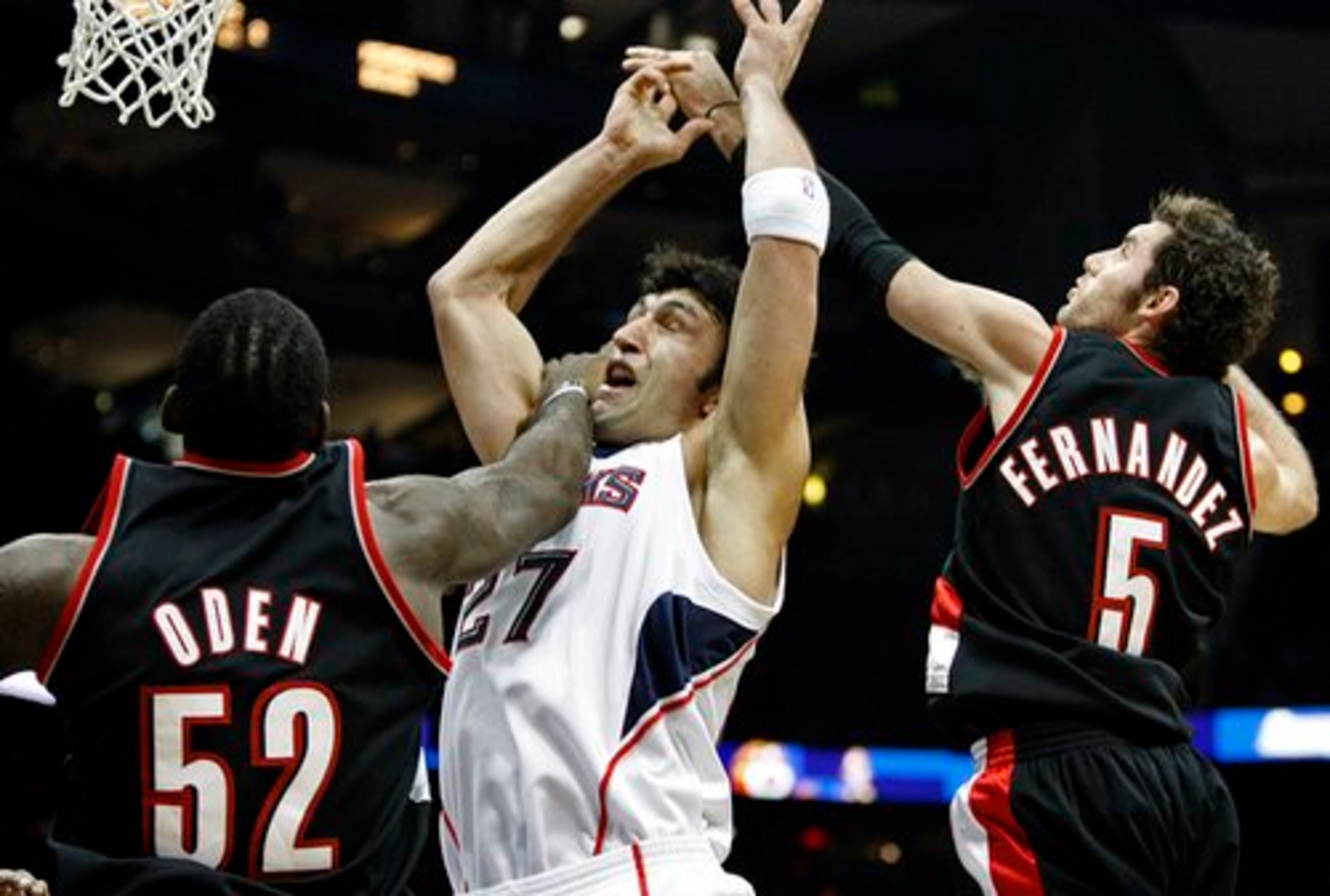 Hawks center Zaza Pachulia draws the foul as he is hammered by Portland Trail Blazers' Greg Oden (52) and Rudy Fernandez.