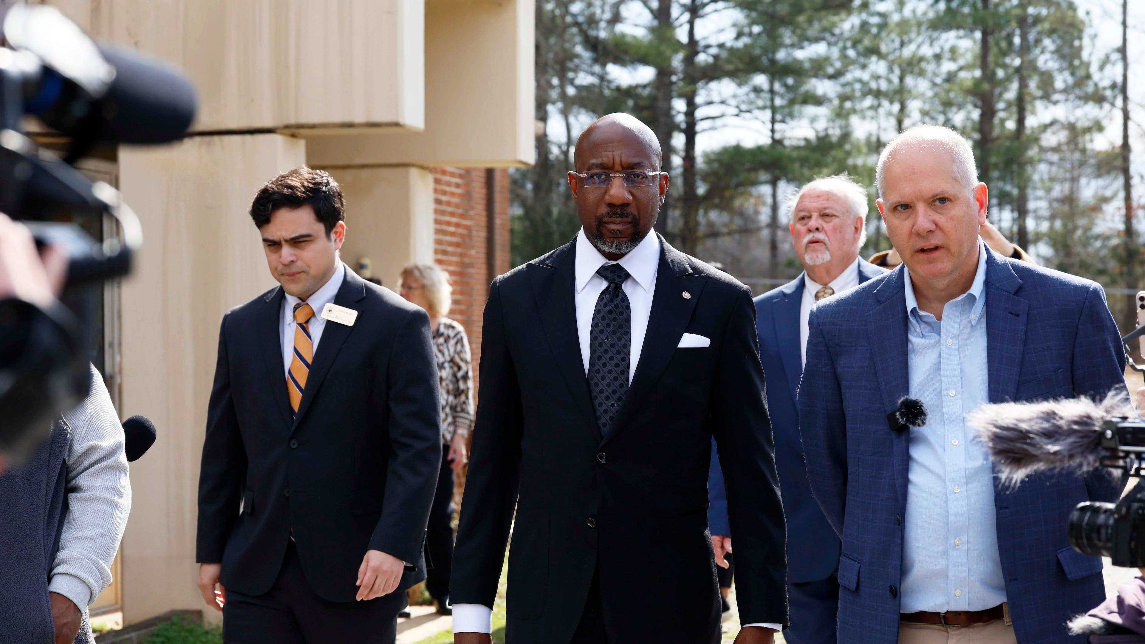 Social Circle City Manager Eric Taylor (right) walks with U.S. Sen. Raphael Warnock (center), D-Ga., as they tour a city water treatment facility on Monday, March 2, 2026. Social Circle officials say the administration's plan to use a warehouse as an immigration detention facility would put too much pressure on the city's water and sewer resources and remove more than $1 million from its tax rolls. (Miguel Martinez/AJC)