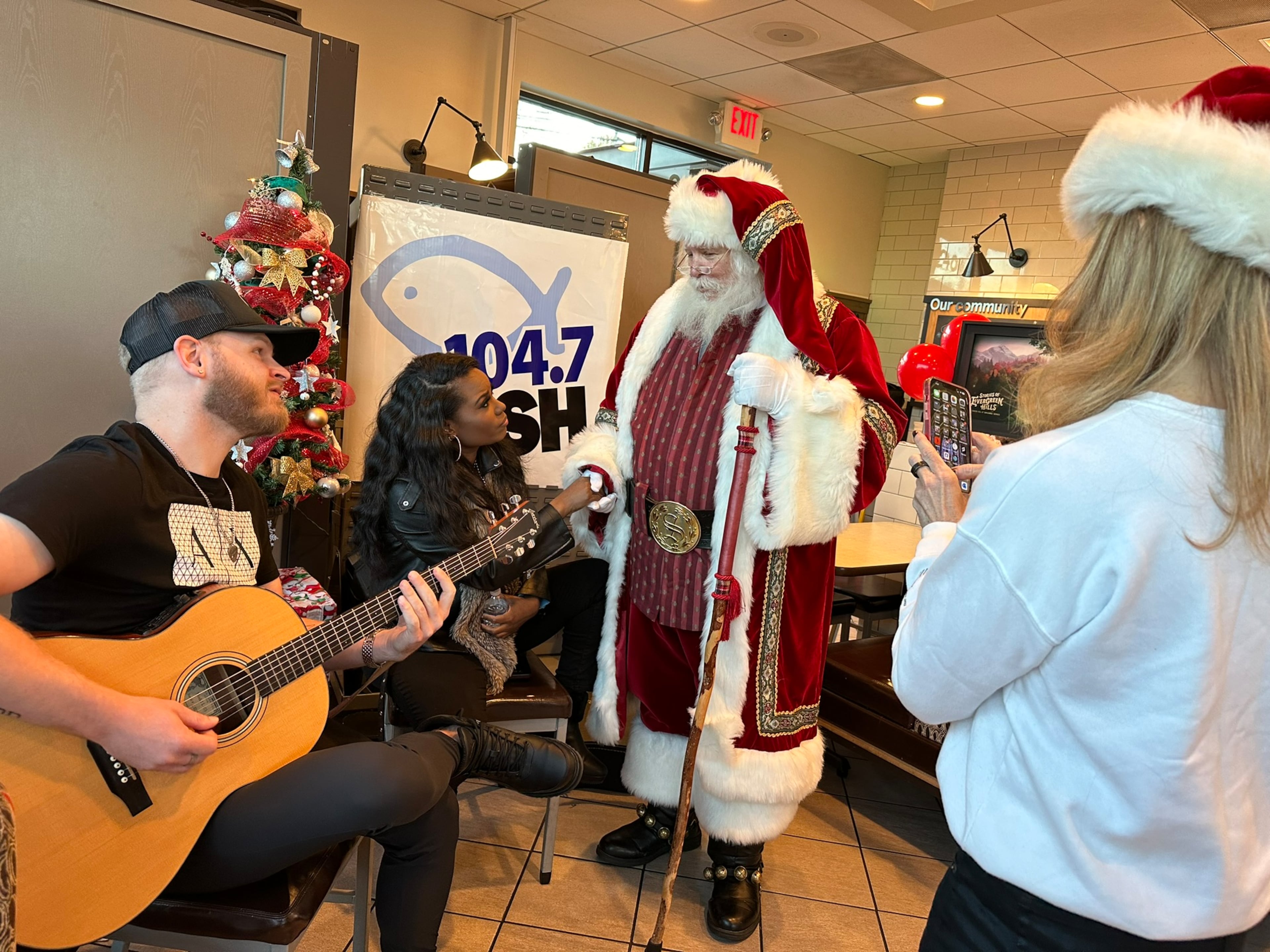 Crystal Nicole (second to left) performed at a Chick fil-A in Dunwoody for Fish 104.7's Christmas Wish program. Santa and afternoon host Beth Bacall are there, too. RODNEY HO/rho@ajc.com