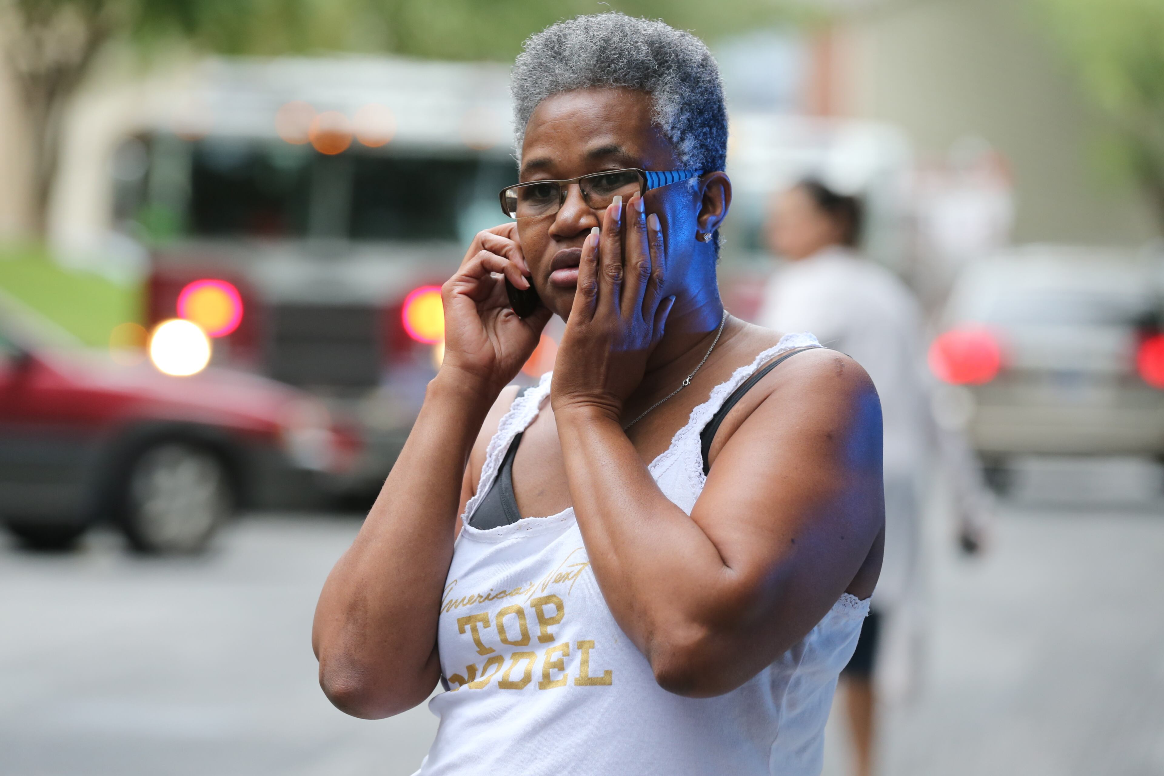 A woman talks on the phone as Cobb firefighters respond to a blaze at an apartment building on Powder Springs Road just south of Marietta on Friday, August 16, 2013.