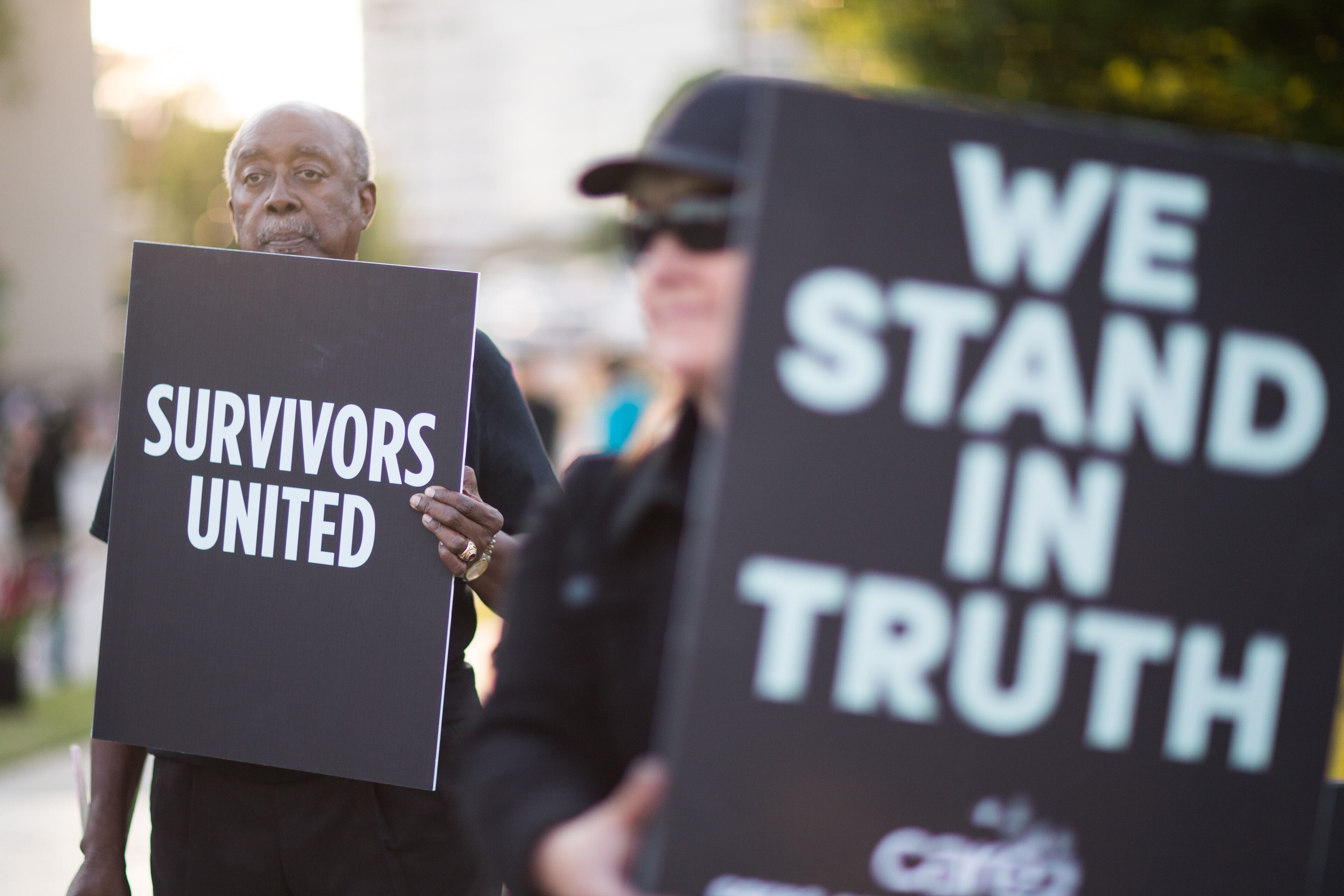 Bill Thompson, left, father of Kaya Thompson, who says Bill Cosby sexually assaulted her, holds a sign at the entrance of the Cobb Energy Performing Arts Centre, Saturday, May 2, 2015, in Atlanta, Ga. A group of protesters gathered to speak out against Cosby's performance after allegations that he sexually assaulted several women throughout his career. (SPECIAL/BRANDEN CAMP)