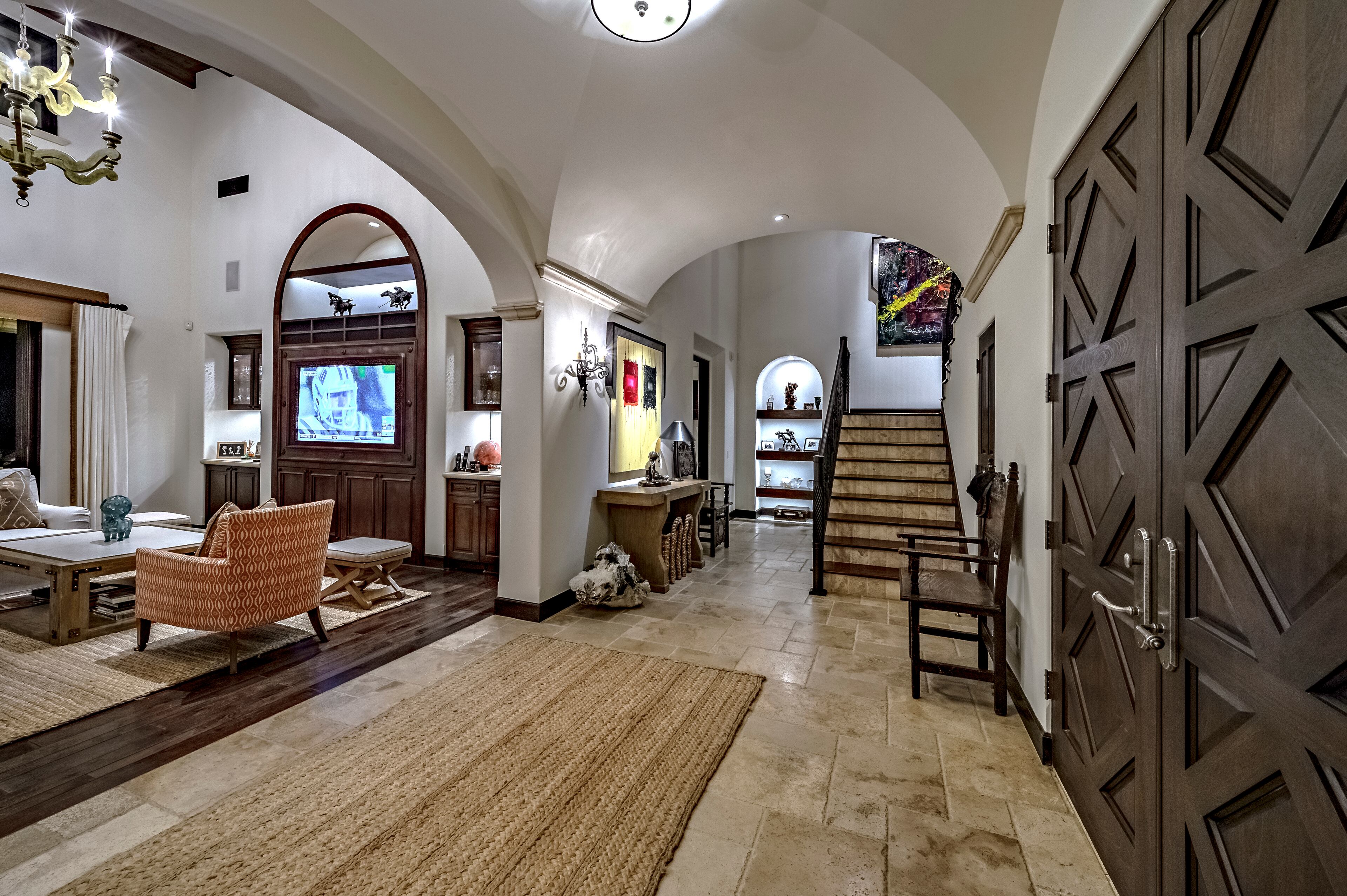 Heavy wood double doors open up to a vaulted ceiling in the entryway, which leads into the double-height living room. Rocky star and all-around action movie legend Sylvester Stallone has put his desert home in a gated La Quinta, Calif., community up for sale at $4.2 million. The 5,173-square-foot, four-bedroom, 4.5-bathroom home features details such as arched doorways, exposed beams, and plenty of space to hang his paintings, since he’s not just an actor—he’s an artist, too. Listing courtesy of Josh Reef, Hurwitz James Company