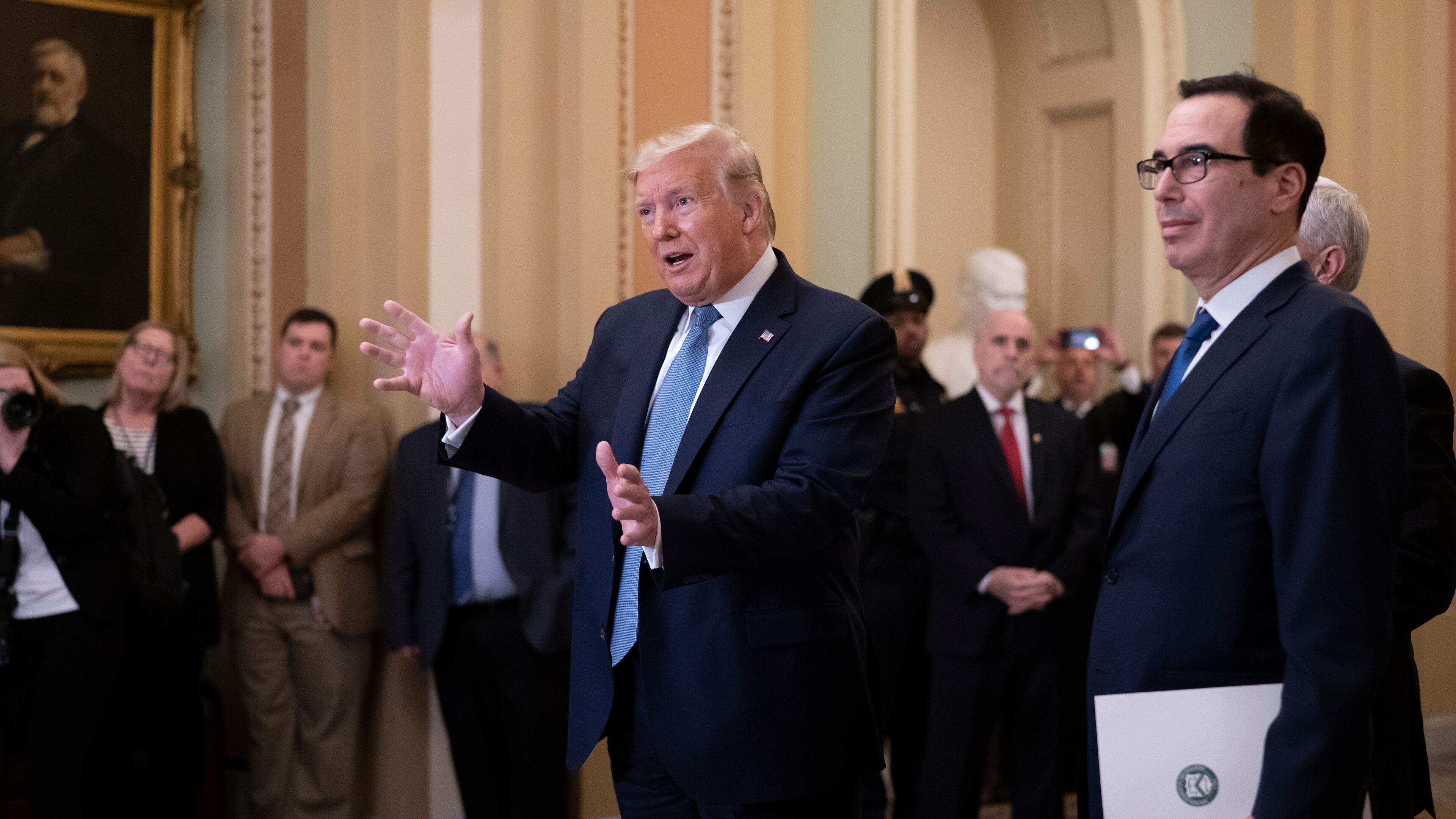 President Donald Trump, joined by Treasury Secretary Steven Mnuchin, right, speaks to reporters after meeting with Republican senators, on Capitol Hill in Washington, Tuesday, March 10, 2020. (AP Photo/J. Scott Applewhite)