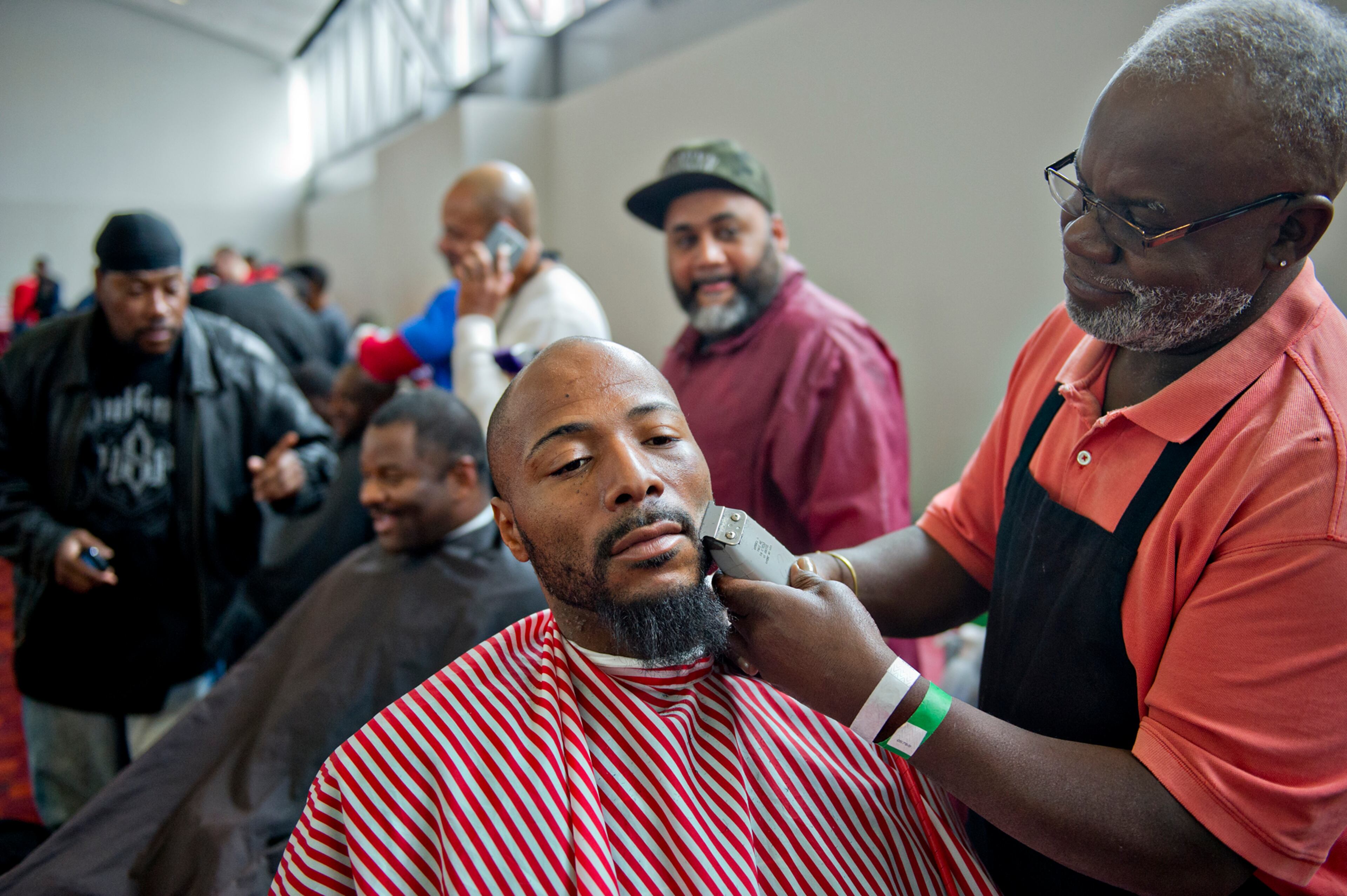 Shauntell Johnson (left) gets his beard trimmed by Slack Williams during the 44th annual Hosea Feed the Hungry and Homeless Thanksgiving Holiday Dinner at the Georgia World Congress Center in Atlanta on Thursday, November 27, 2014. The annual event feeds thousands of homeless people around the metro area as well as provides showers, haircuts, clothes and other critical serves at no cost.