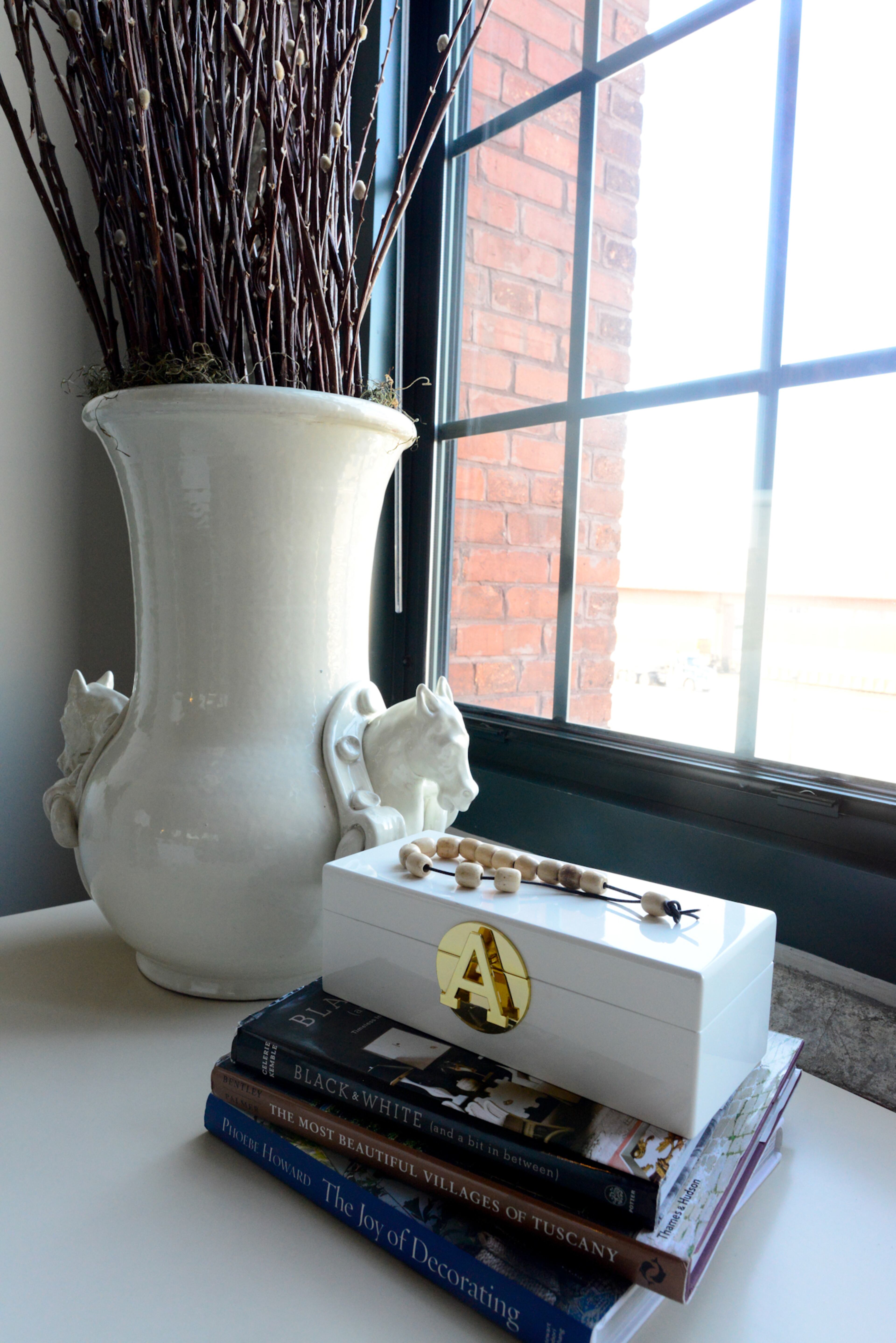 A box with the homeowner's initial and desk were selected by friend and interior designer, Kat Nelson, while the white ceramic vase is among the items from Thrive and Design.
