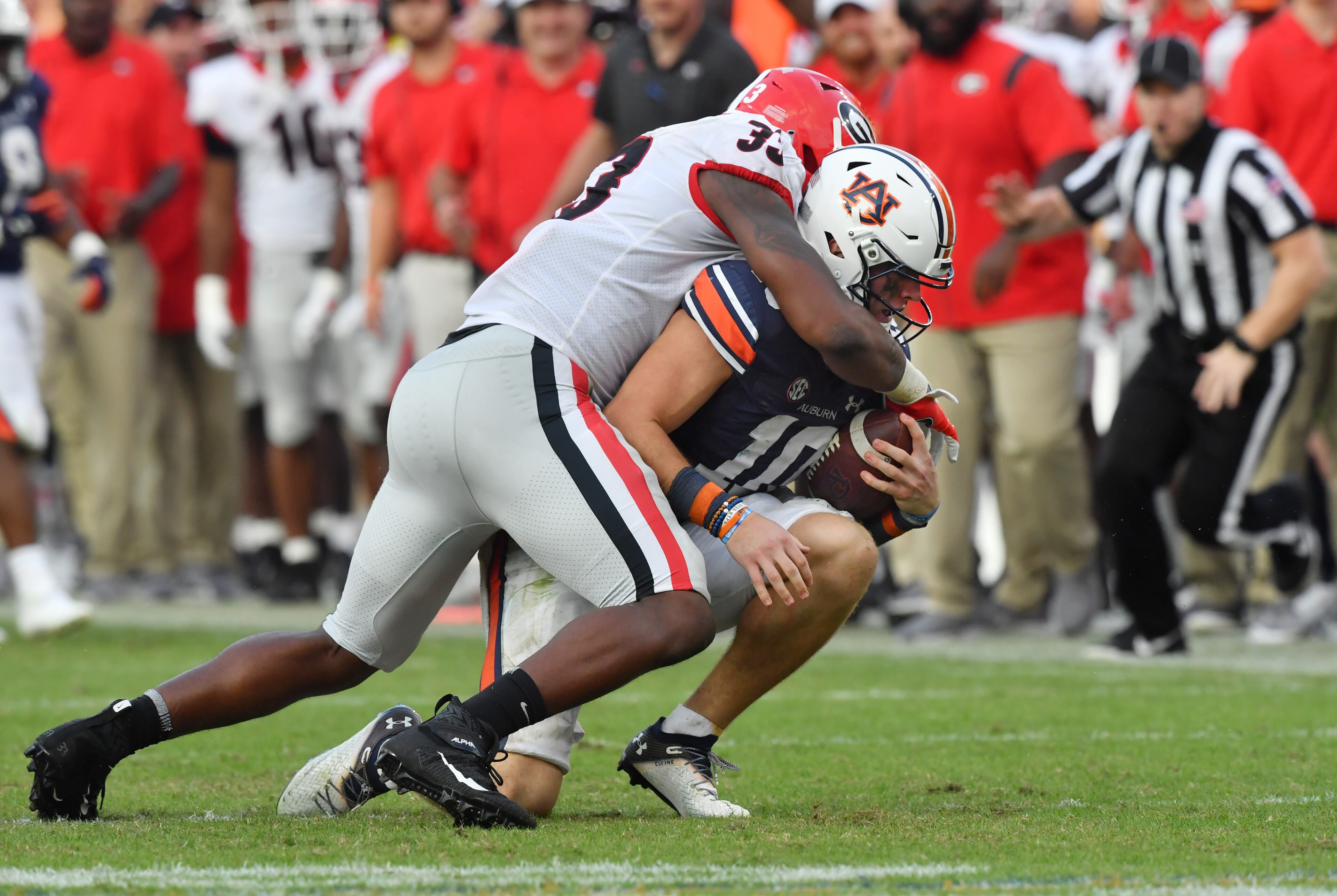 Auburn quarterback Bo Nix (10) is sacked by Georgia linebacker Robert Beal Jr. (33). (Hyosub Shin / Hyosub.Shin@ajc.com)