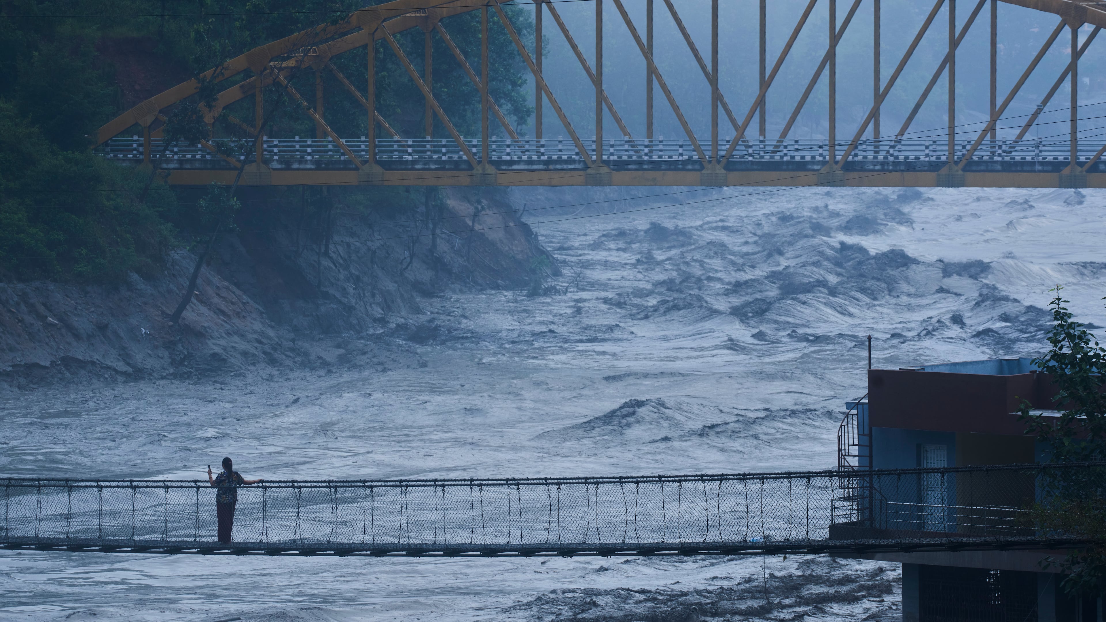 A resident looks at the swollen Trishuli river in Galchhi, Dhading District, Nepal, Sunday, Aug. 30, 2026. (AP Photo/Niranjan Shrestha)