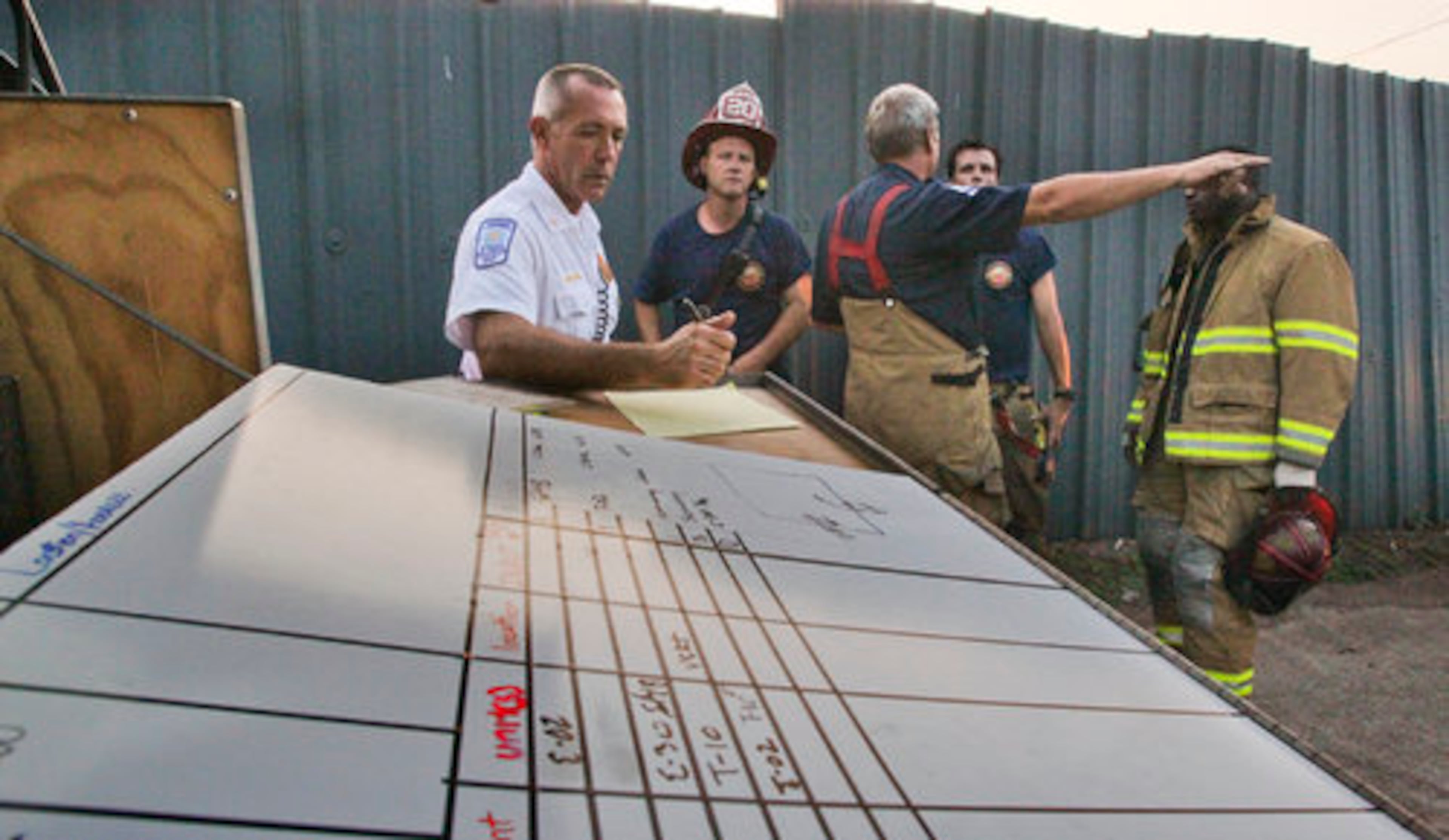 Battalion Chief Todd Edwards works at the command post during the fire. "As our companies arrived, they started getting reports from the residents who had already escaped that we had people still trapped in the residence," Edwards said.