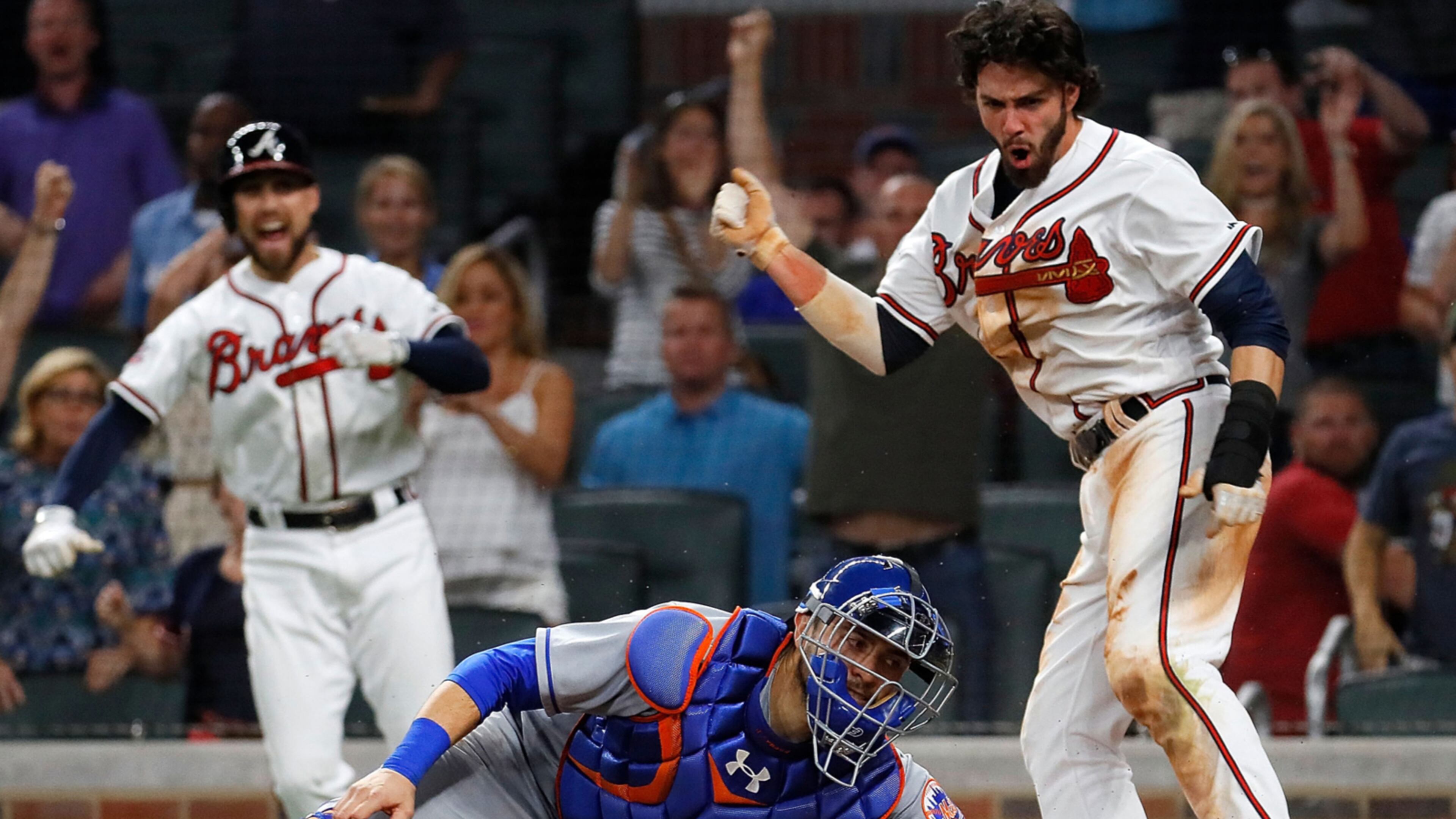 Braves’ Dansby Swanson scores the game-winning run as he slides past Mets catcher Travis d'Arnaud on a RBI hit by Rio Ruiz in the ninth inning at SunTrust Park on June 9, 2017 in Atlanta.