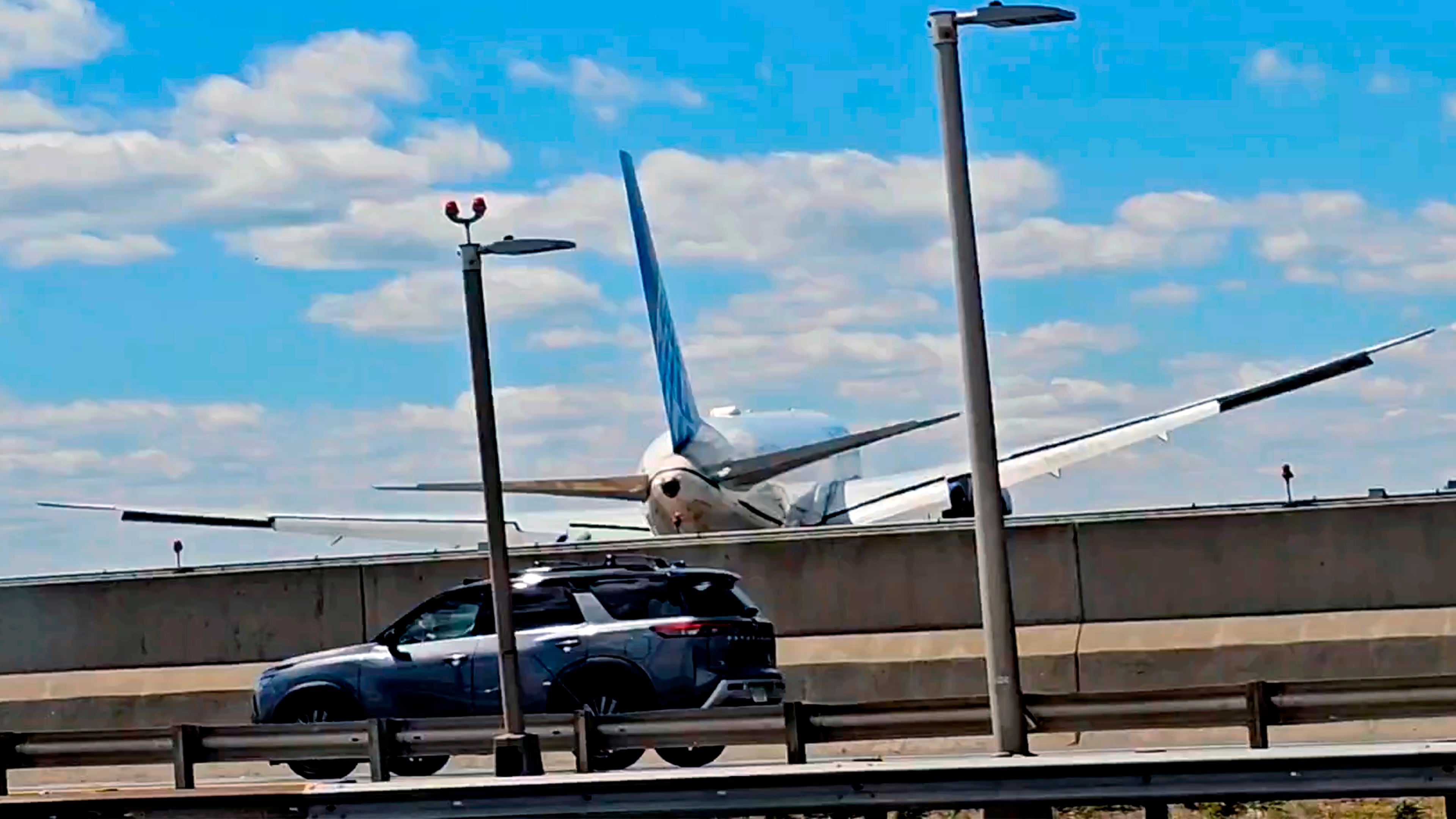 A United Airlines plane is seen in a still image taken from video after hitting a semitrailer truck and a light pole on the New Jersey Turnpike as it lands at Newark Liberty International Airport, Sunday, May 3, 2026. (Patrick Oyulu, via AP)