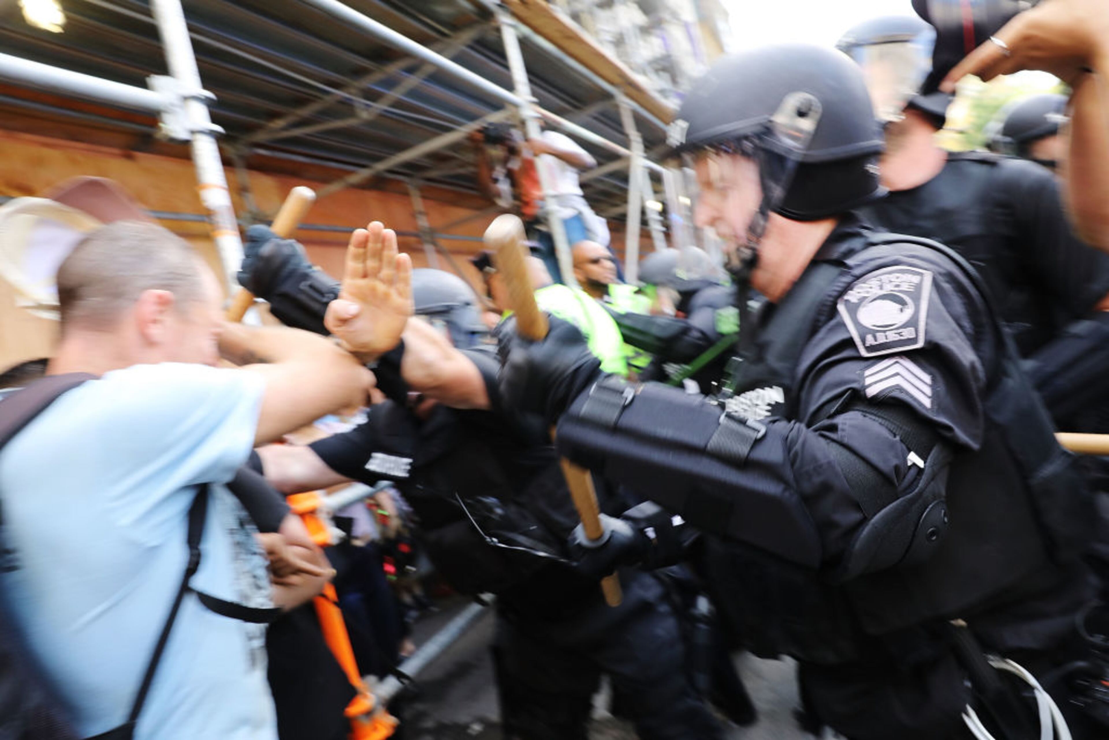 BOSTON, MA - AUGUST 19: Protesters face off with riot police escorting conservative activists following a march in Boston against a planned 'Free Speech Rally' just one week after the violent 'Unite the Right' rally in Virginia left one woman dead and dozens more injured on August 19, 2017 in Boston, United States. Although the rally organizers stress that they are not associated with any alt-right or white supremacist groups, the city of Boston and Police Commissioner William Evans are preparing for possible confrontations at the afternoon rally. (Photo by Spencer Platt/Getty Images)