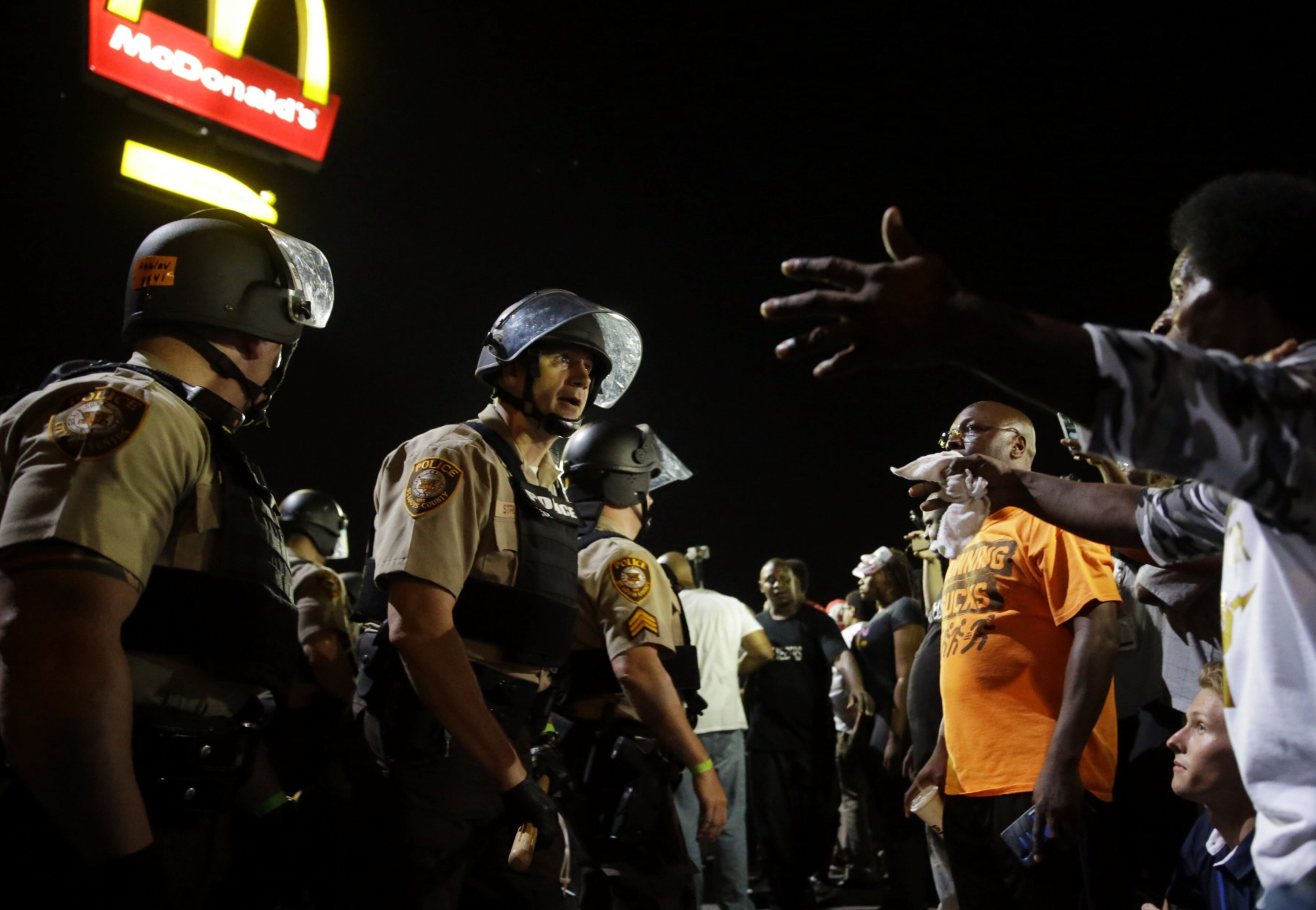 Officers and protesters face off along West Florissant Avenue on Aug. 10, 2015, in Ferguson, Mo. Ferguson was a community on edge again Monday, a day after a protest marking the anniversary of Michael Brown's death was punctuated with gunshots.