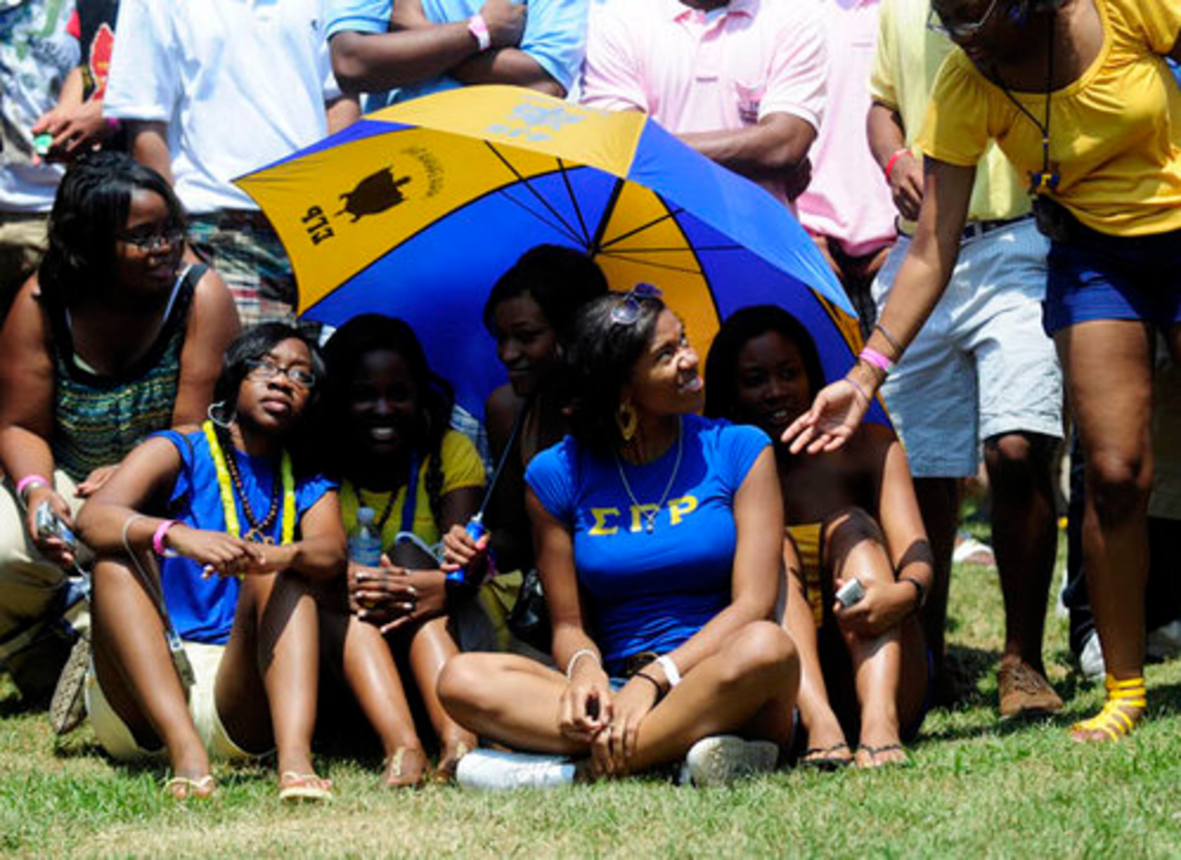 From left, Rosline Sumpler, 21, Christina Smith, 23, Alicia Brooks, 23, Brittney A. Williams, 20, and Angened Pounds, 20, shade themselves from the sun.