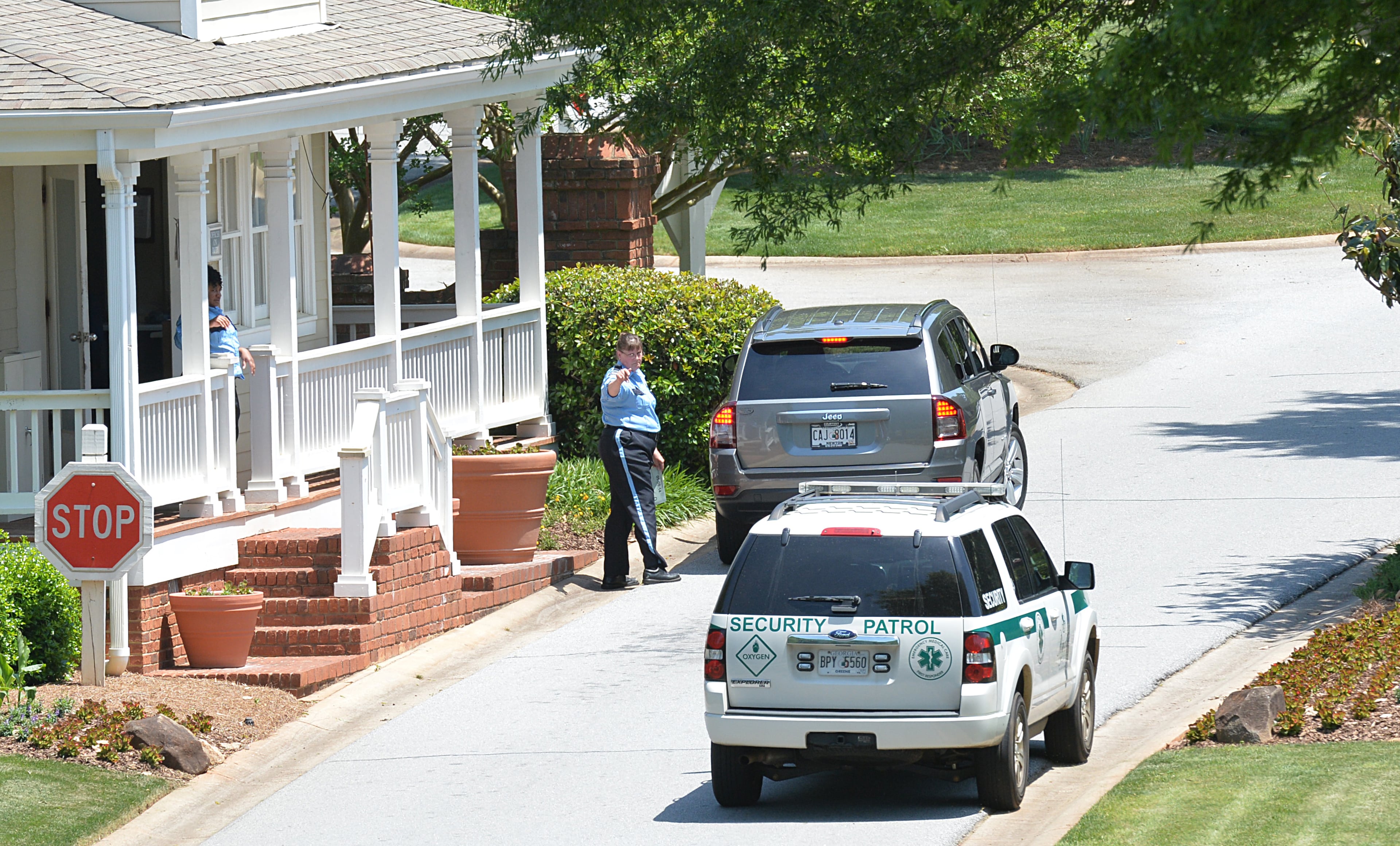 Security guards monitor traffic through the gate off Reynolds Drive at Great Waters Reynolds Plantation, the gated subdivision of the Lake Oconee resort community, where an 87-year-old woman believed abducted after her 88-year-old husband was found decapitated in their lakeside home. HYOSUB SHIN / HSHIN@AJC.COM