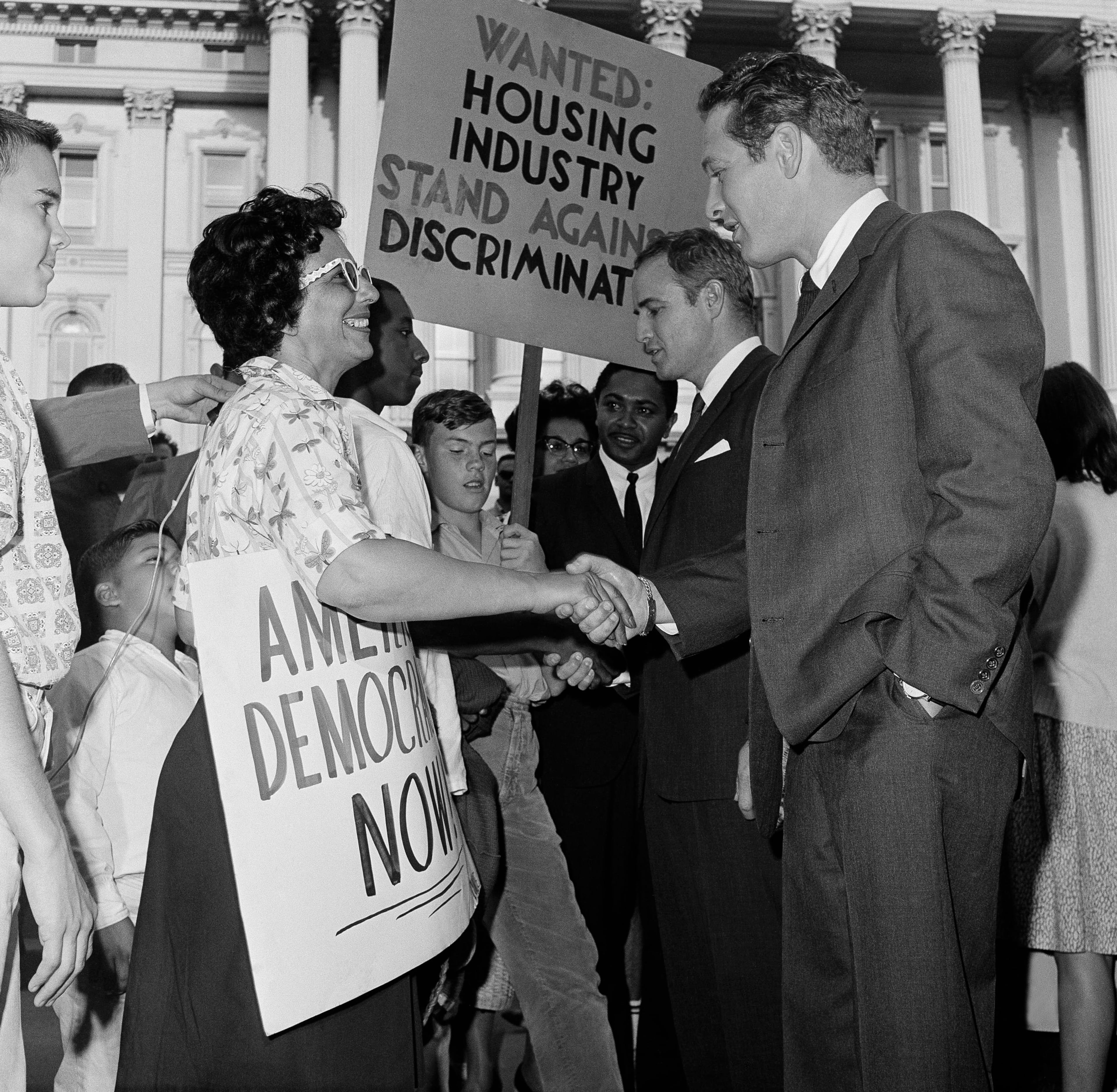 Movie star Paul Newman, right, and Marlon Brando shake hands on June 11,1963 with members of group that marched from Berkeley to urge the California Legislature to act on a housing bill. The actors, pictured on the steps of the State Capitol, flew to Sacramento to urge passage of Gov. Brown's proposal to ban discrimination in private housing. Smiling marcher at left is Mrs. Arlene Slaughter of Oakland. Assemblyman Mervyn Dymally, D-Los Angeles, is next to Brando. Both Brando and Newman later attended the March on Washington. (AP Photo)