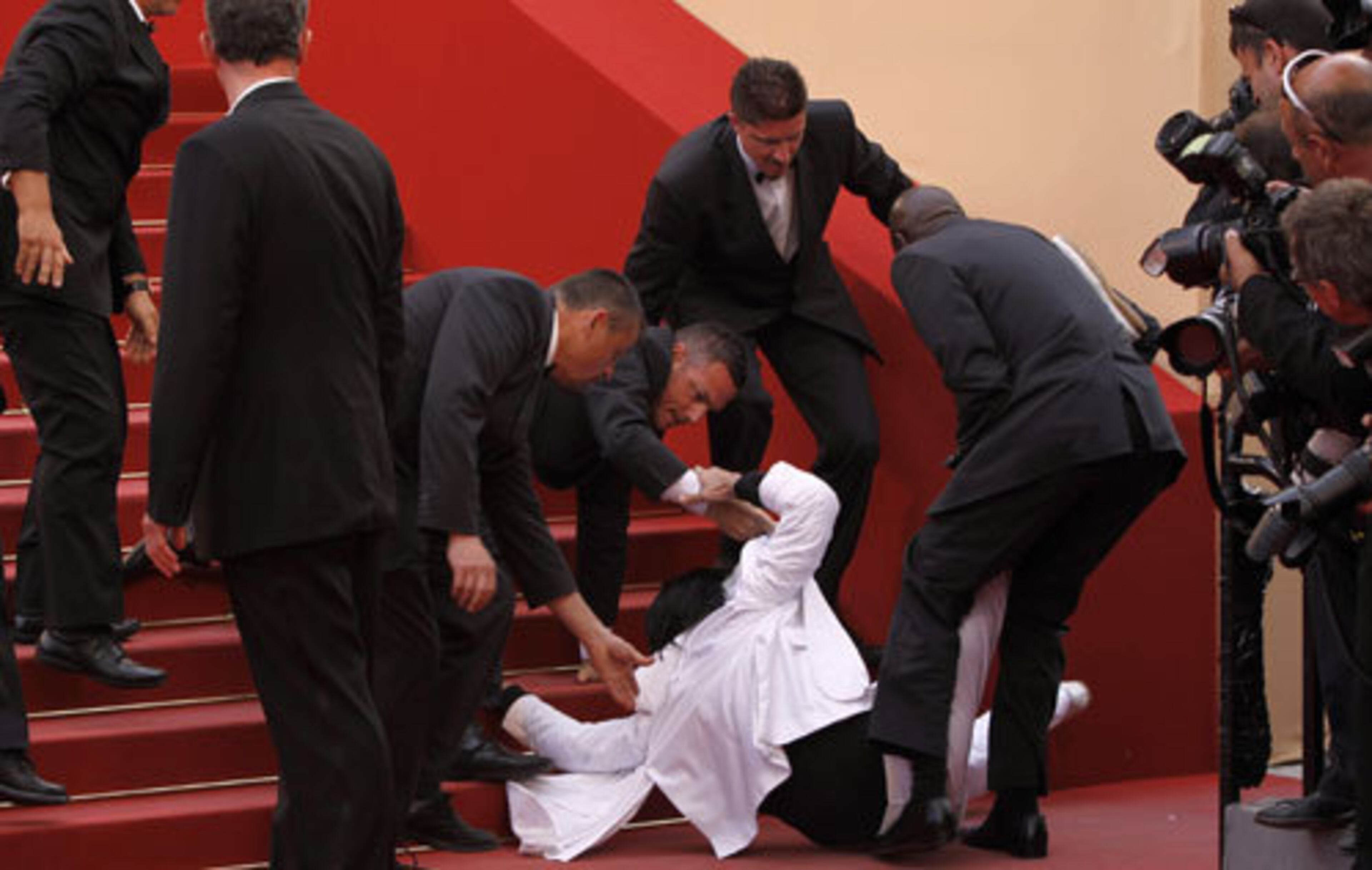 An intruder dressed in white is pulled to the ground by security on the red carpet at the 'Beaver' screening.