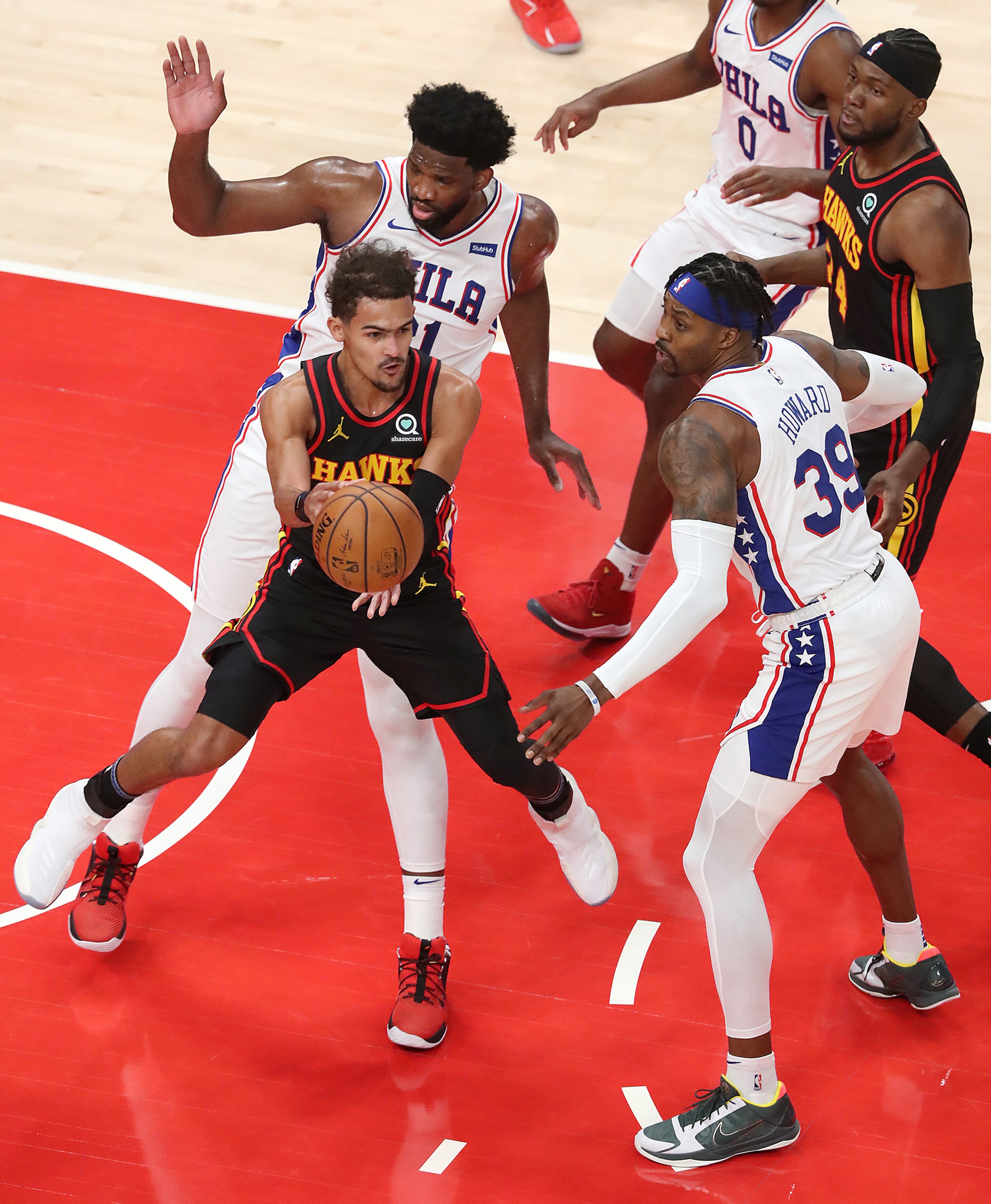 011121 Atlanta: Atlanta Hawks Trae Young passes off against Philadelphia 76ers Dwight Howard in a NBA basketball game on Monday, Jan. 11, 2021, in Atlanta. Curtis Compton / Curtis.Compton@ajc.com”